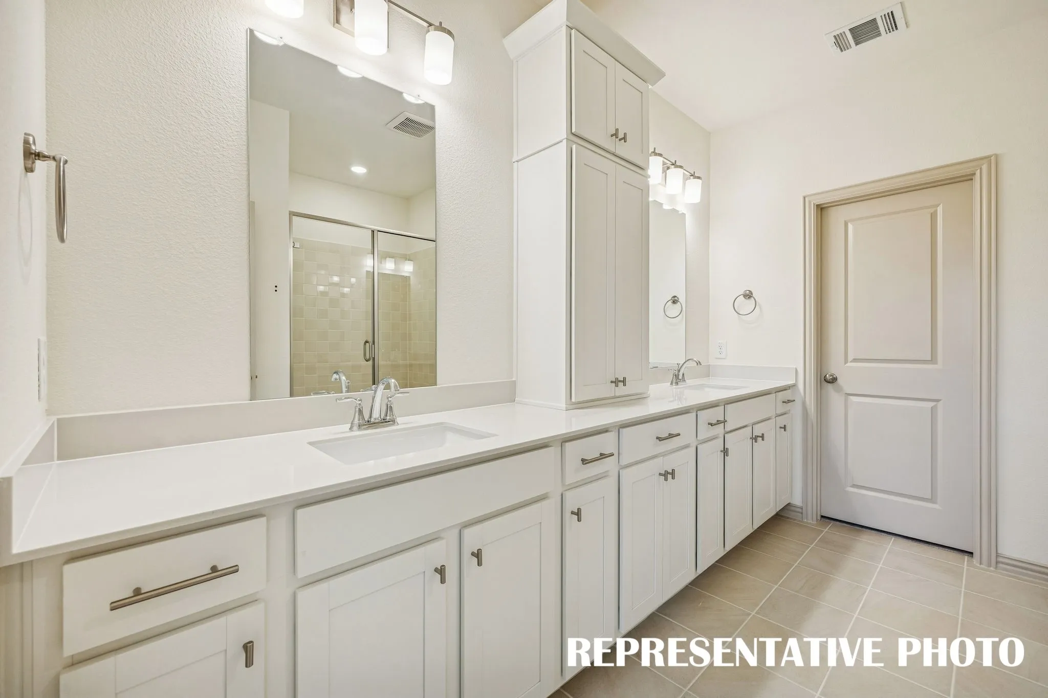Featuring ample storage and vanity space, this owner's bath was designed with two in mind!  REPRESENTATIVE PHOTO