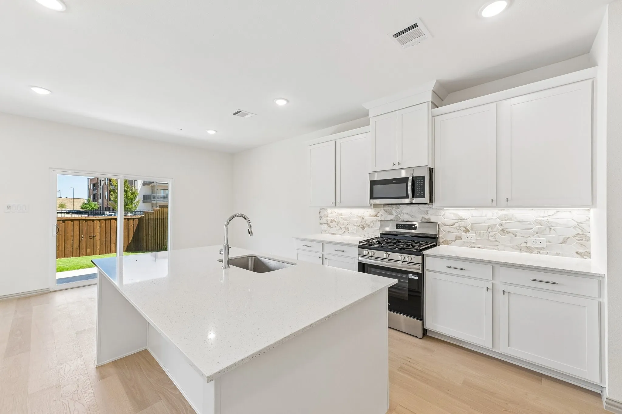 Featuring a color palette with crisp clean whites, this dream kitchen offers ample storage and prep space!