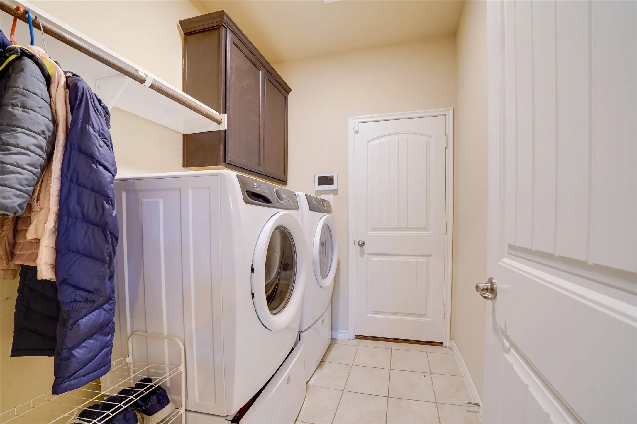 Laundry room with cabinets, separate washer and dryer, and light tile patterned floors