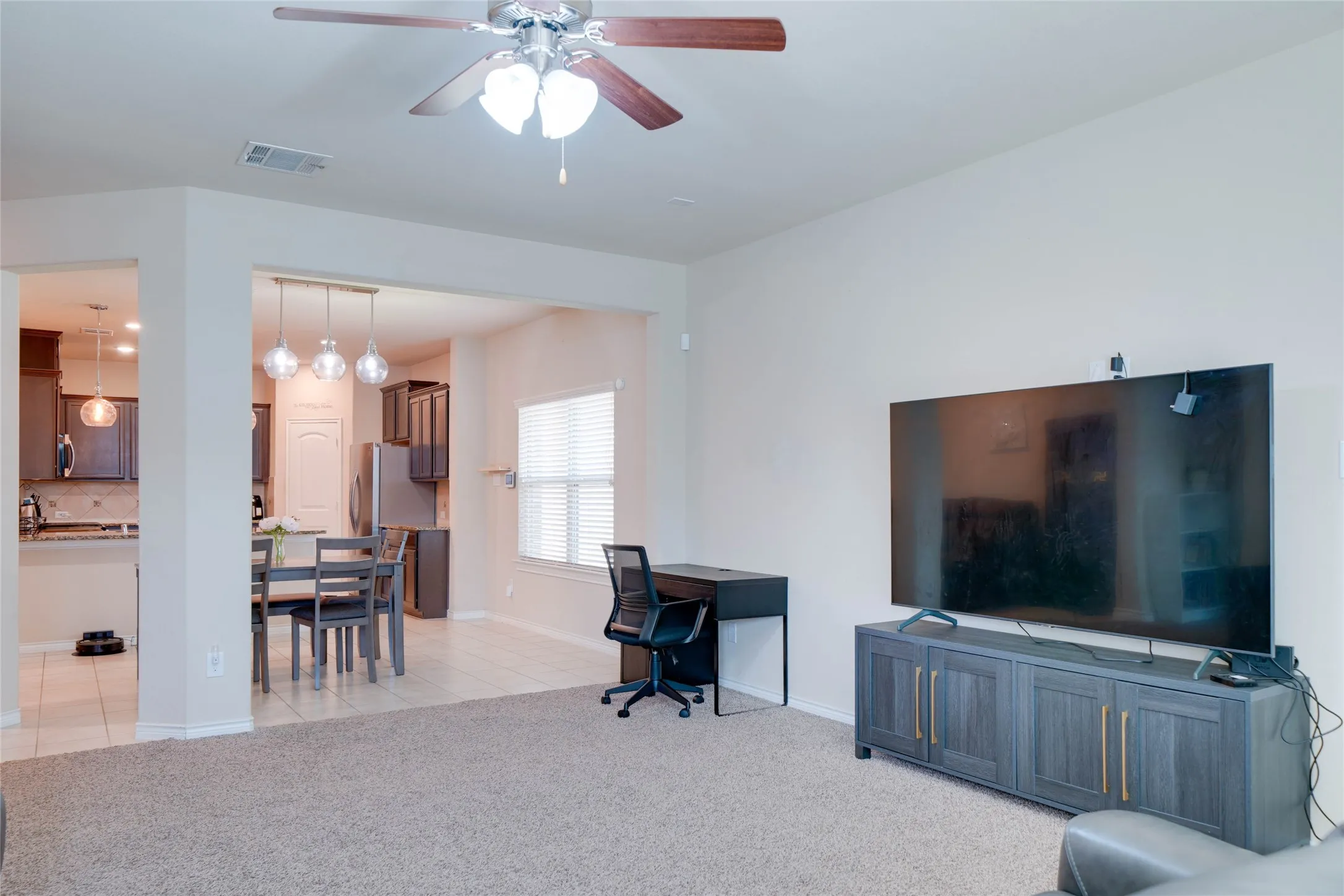 Living room with light colored carpet and ceiling fan