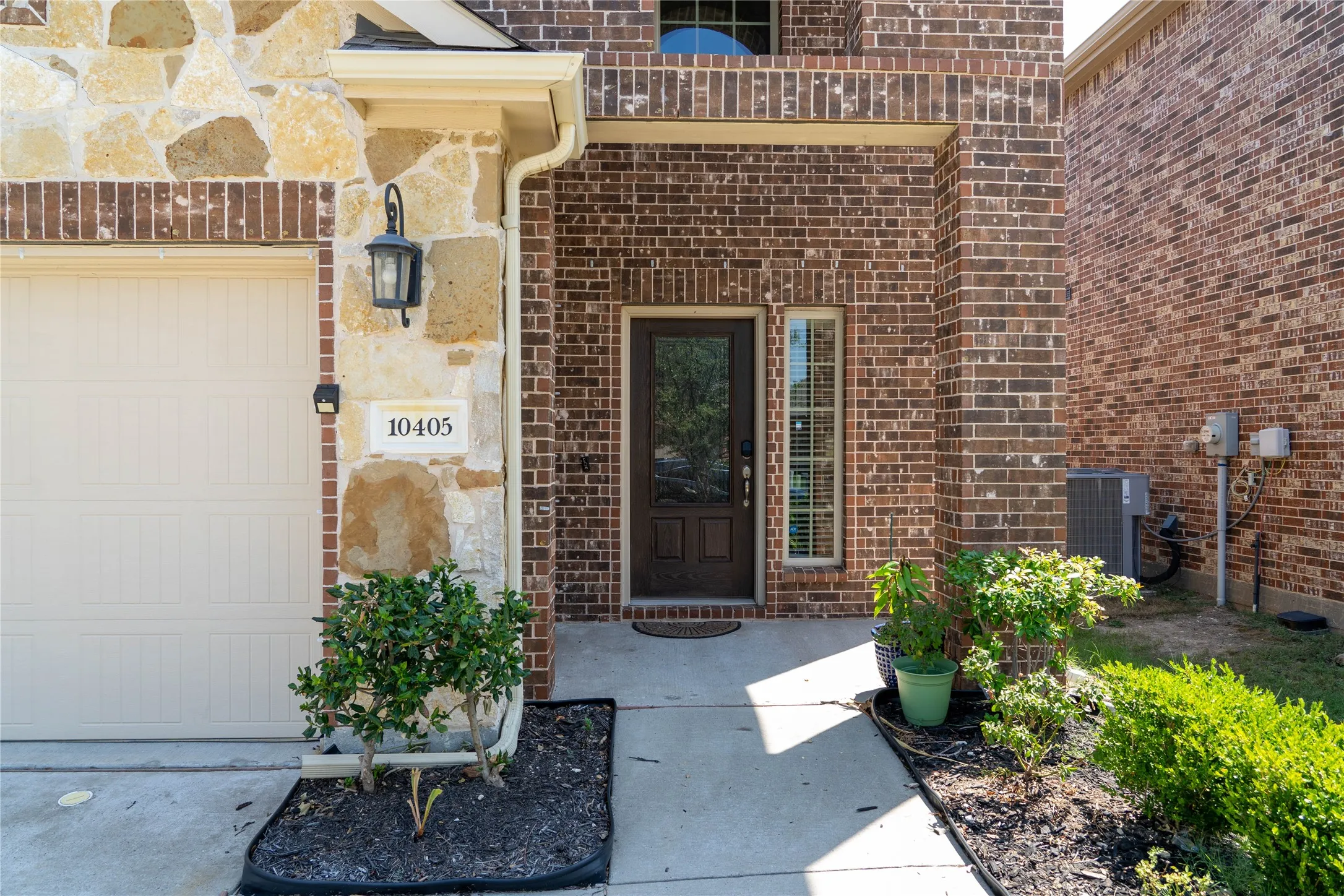 Doorway to property with a garage and cooling unit