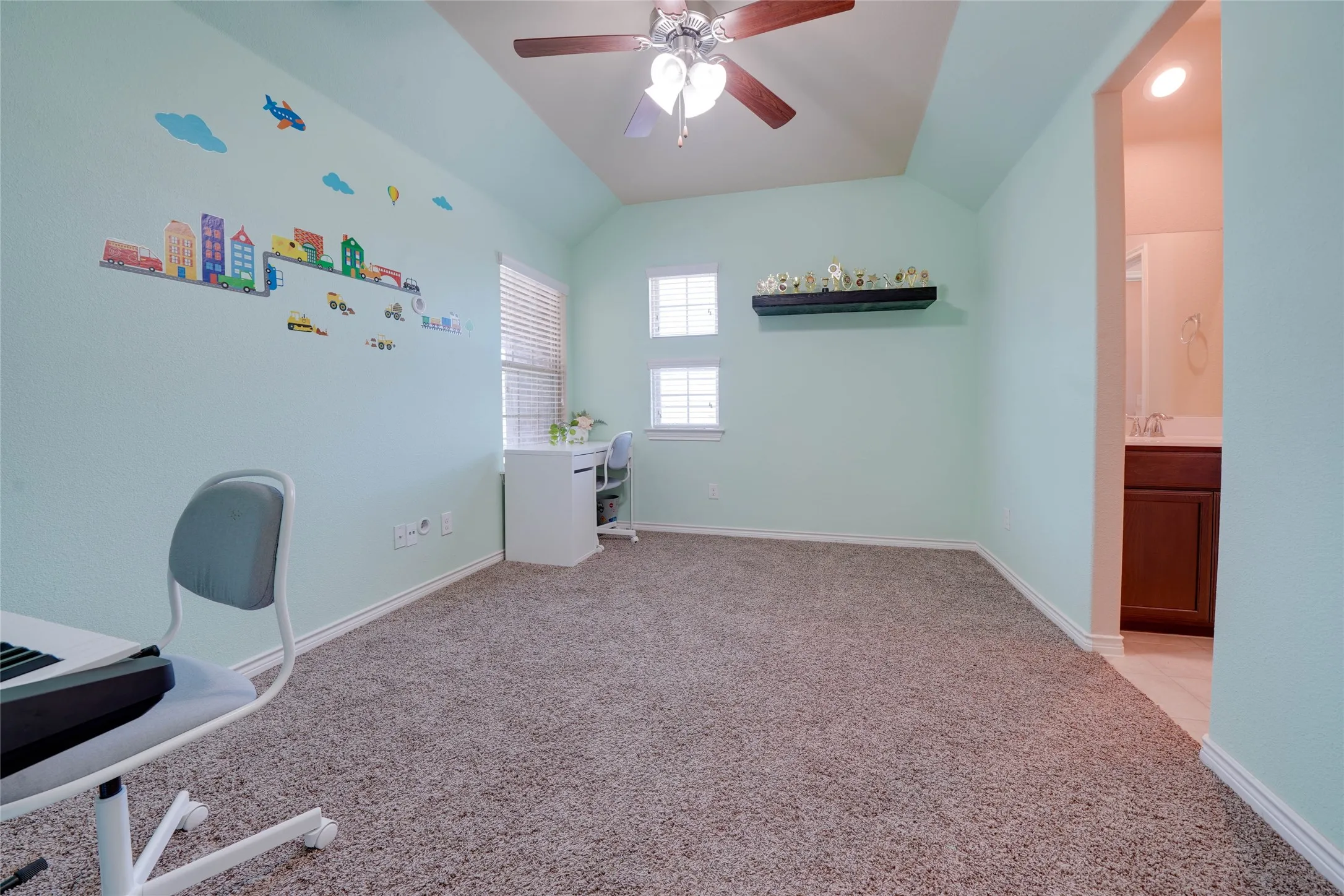 Unfurnished office with light colored carpet, vaulted ceiling, and ceiling fan