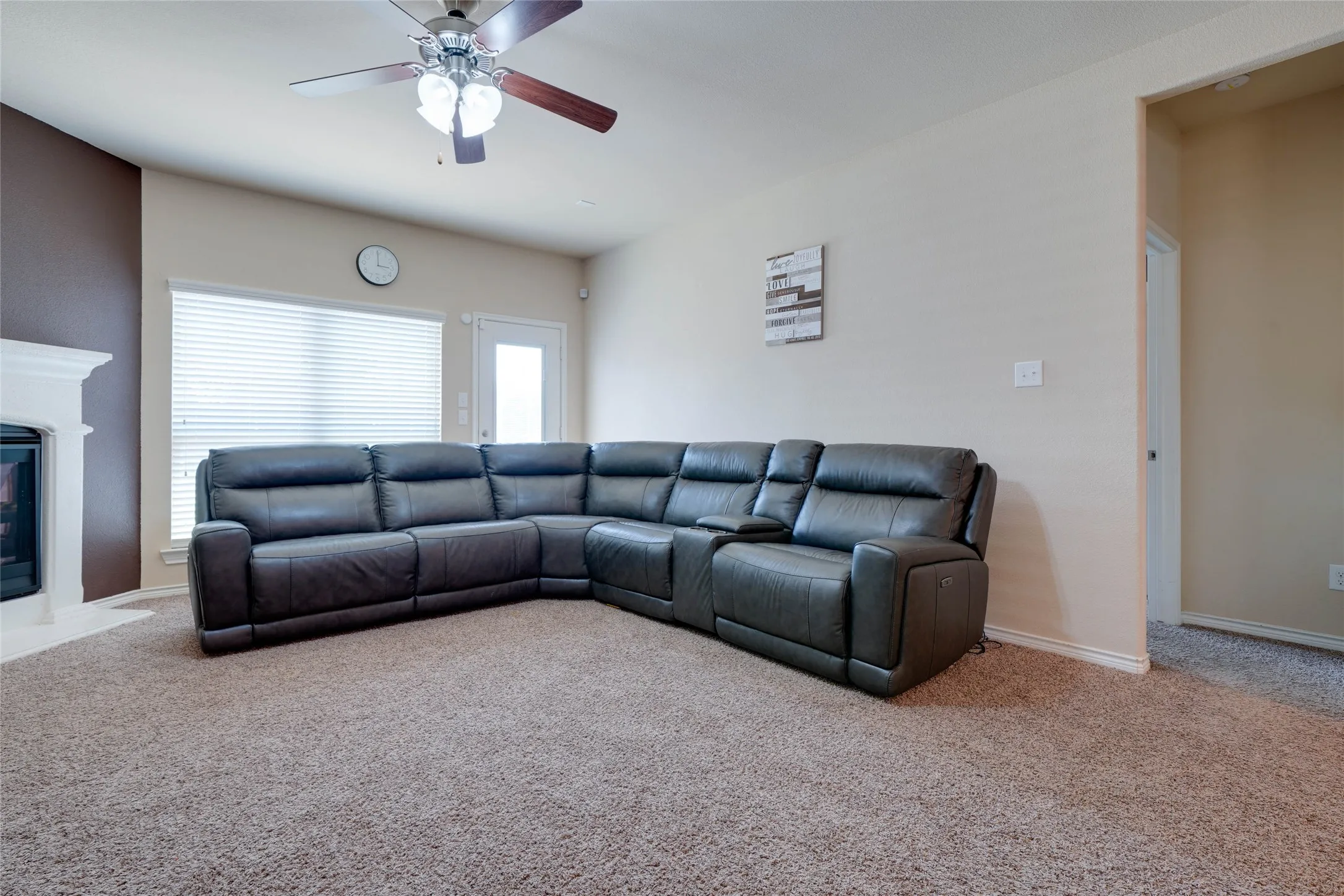 Carpeted living room featuring ceiling fan