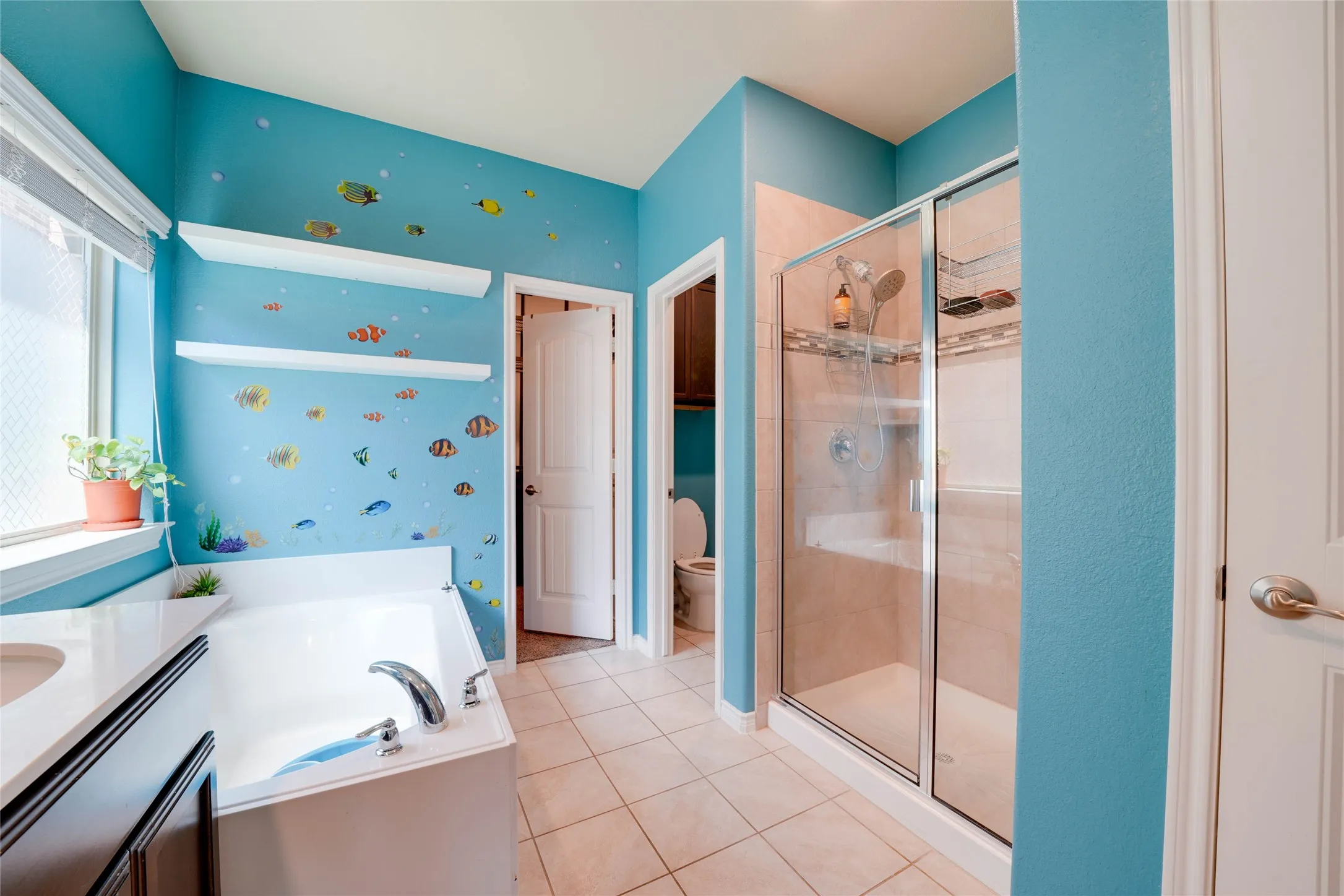Full bathroom featuring tile patterned flooring, separate shower and tub, toilet, and vanity