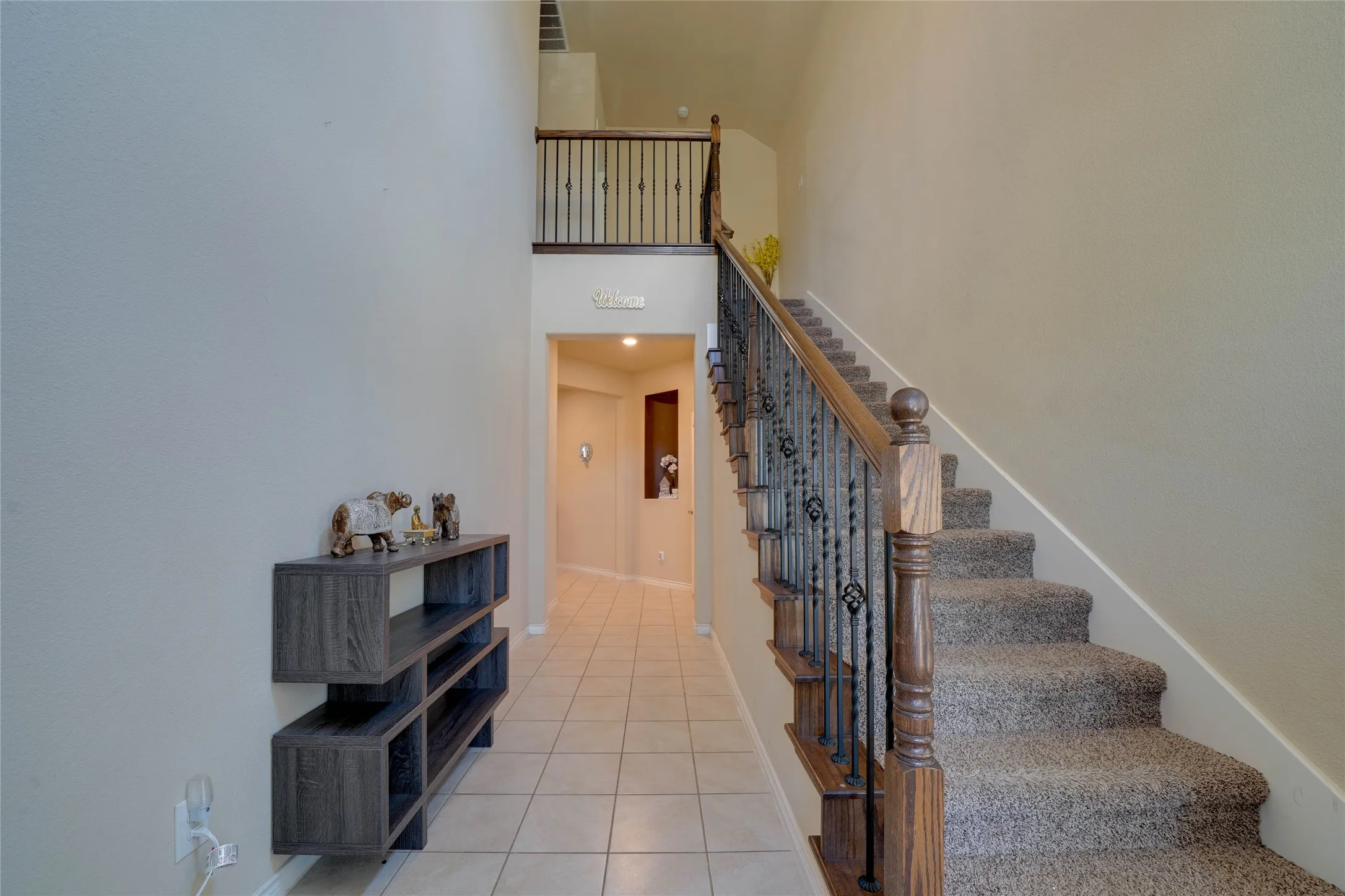 Stairs with a towering ceiling and light tile patterned floors
