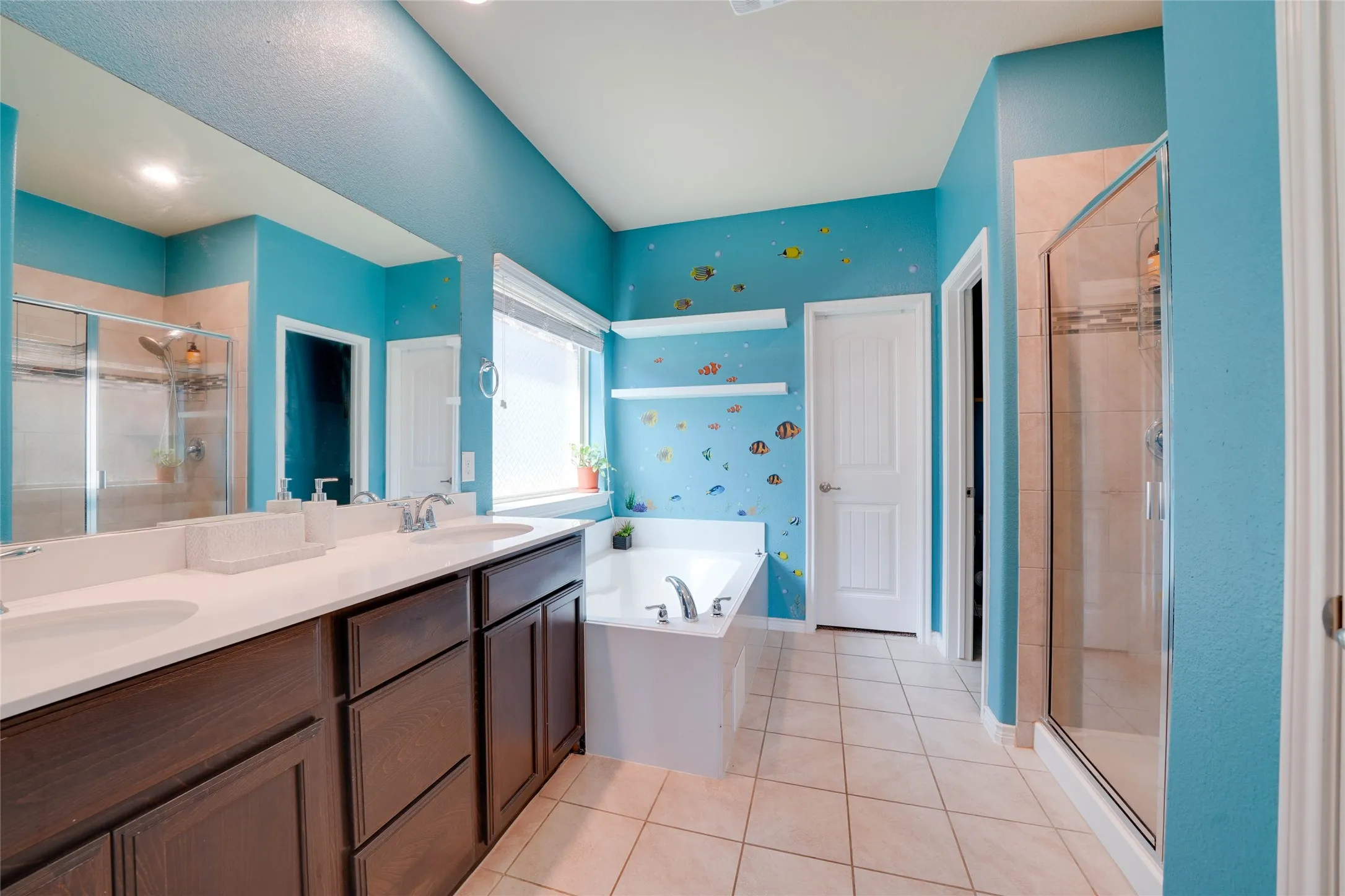 Bathroom featuring shower with separate bathtub, double sink vanity, and tile patterned flooring