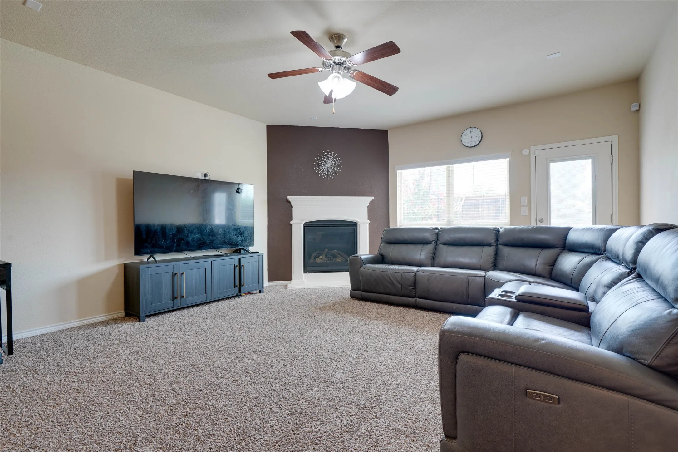 Carpeted living room featuring ceiling fan
