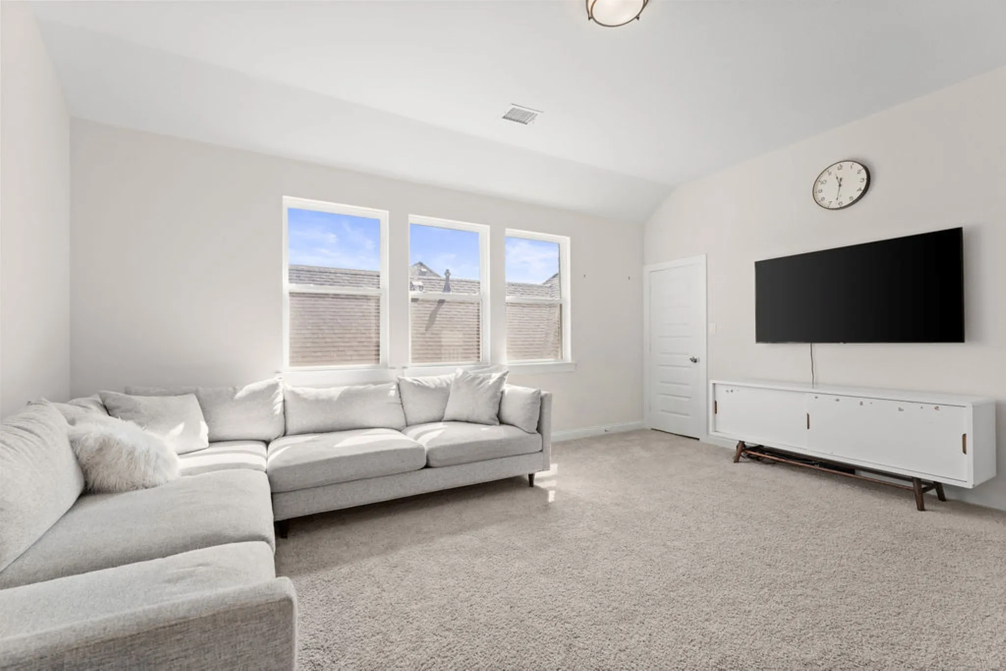 Expansive room with neutral carpeting and light-toned walls