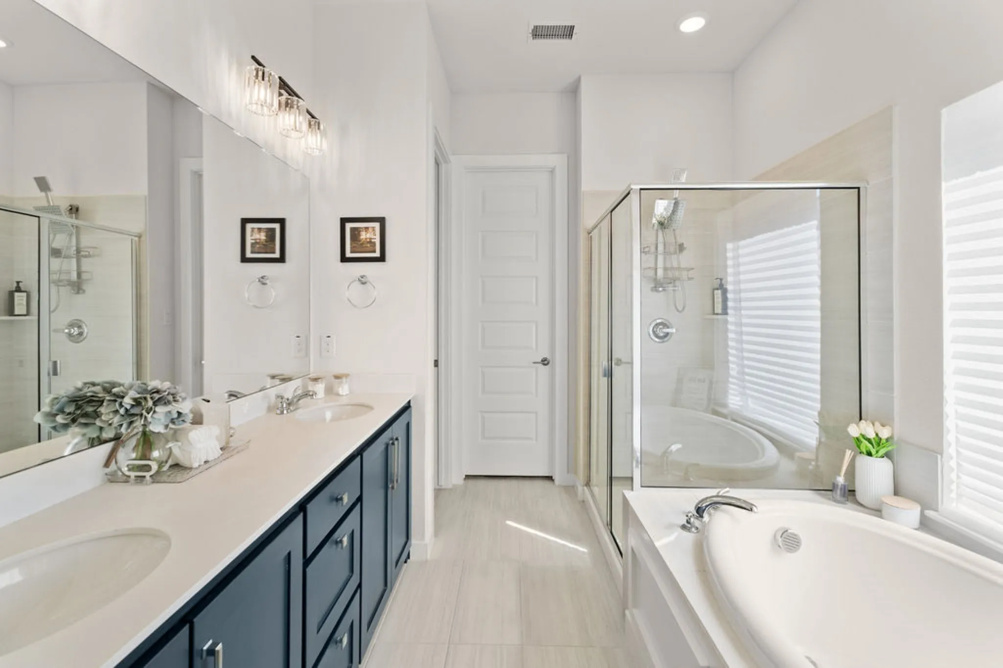 Bathroom featuring a dual vanity with a solid surface countertop, undermount sinks, and a dark wood-finish cabinet