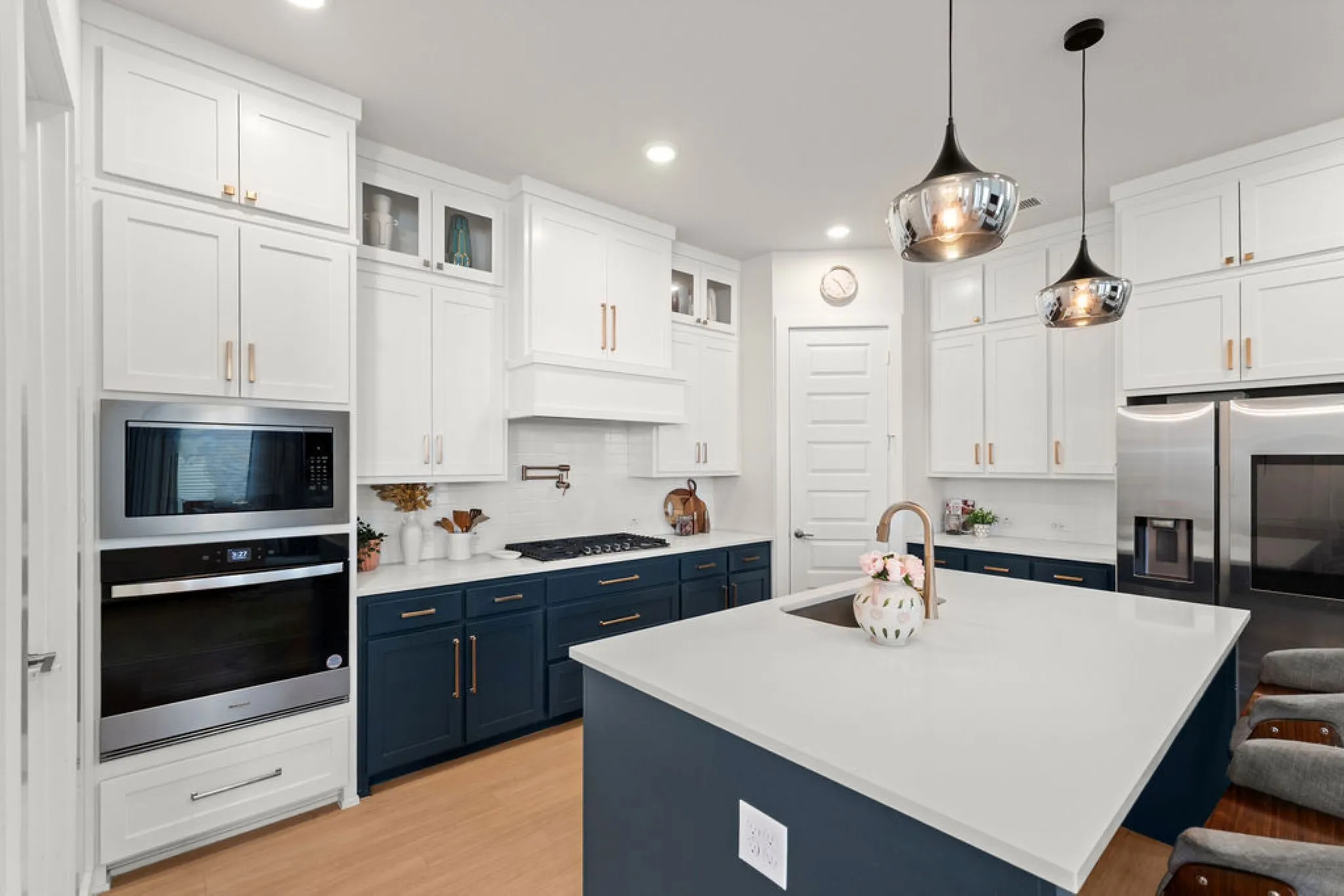 Modern kitchen featuring a large central island with a sink and a gooseneck faucet