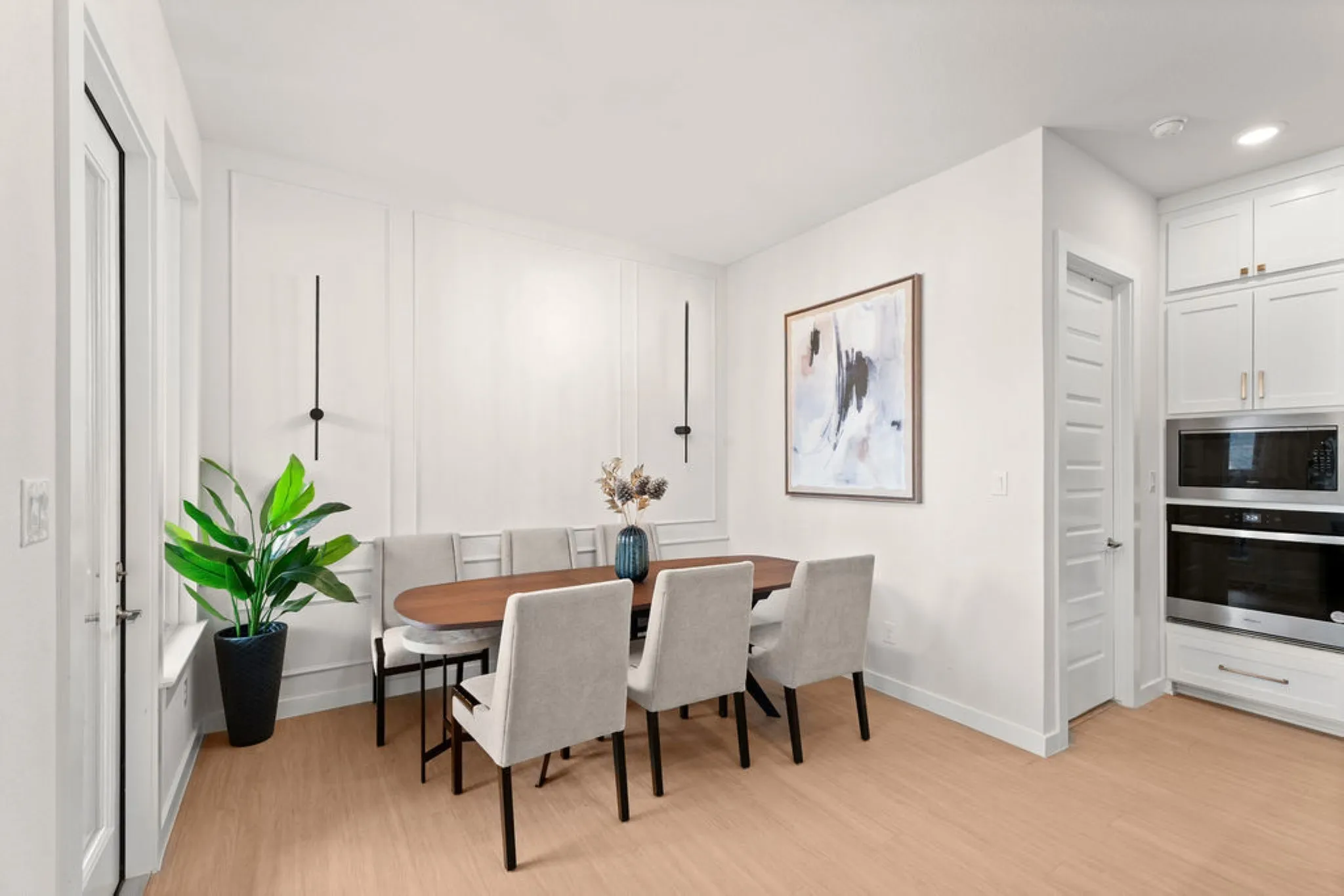 Dining area featuring wainscoting accent wall and wood-finish flooring
