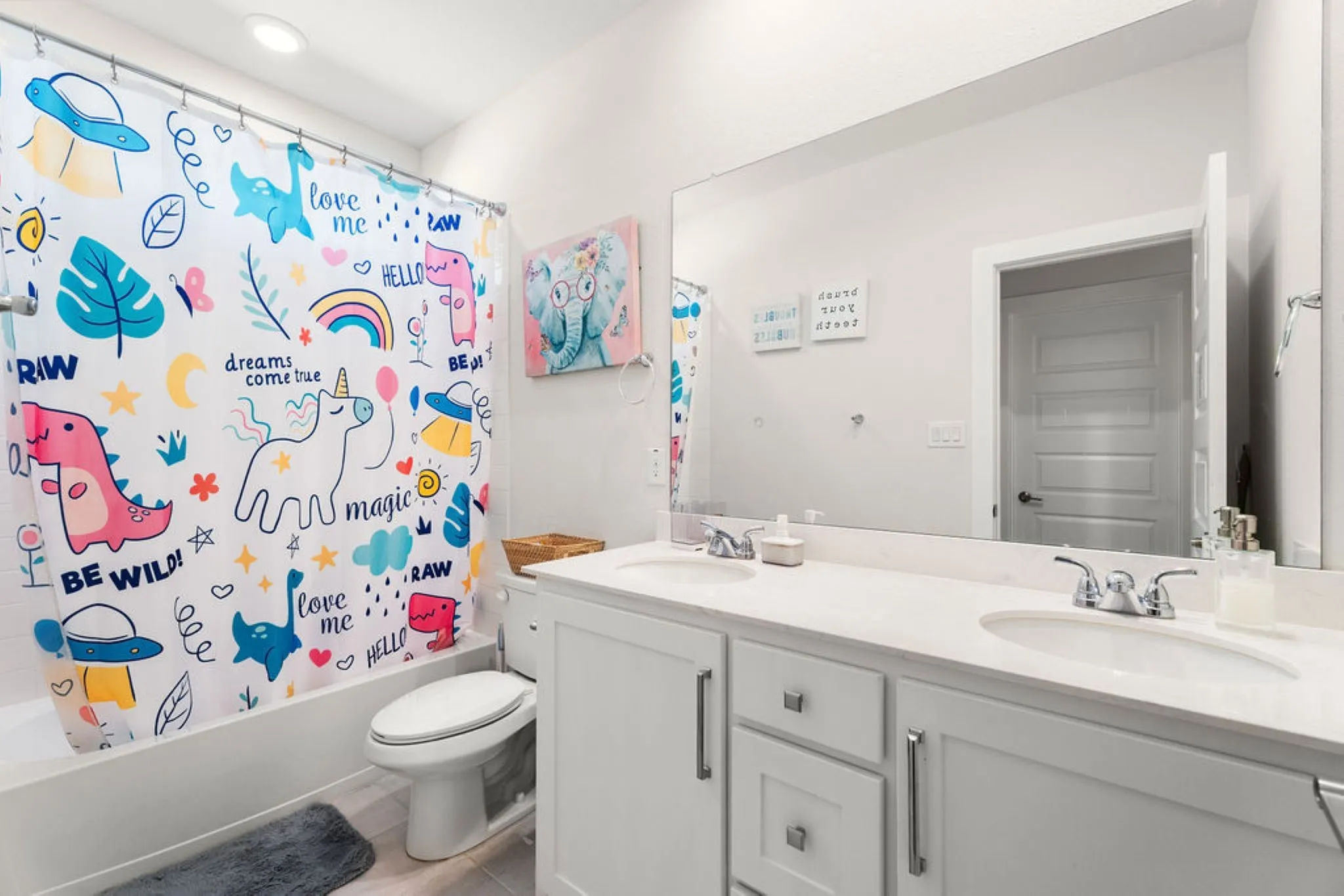White double vanity with integrated sinks, chrome fixtures, and a spacious mirror