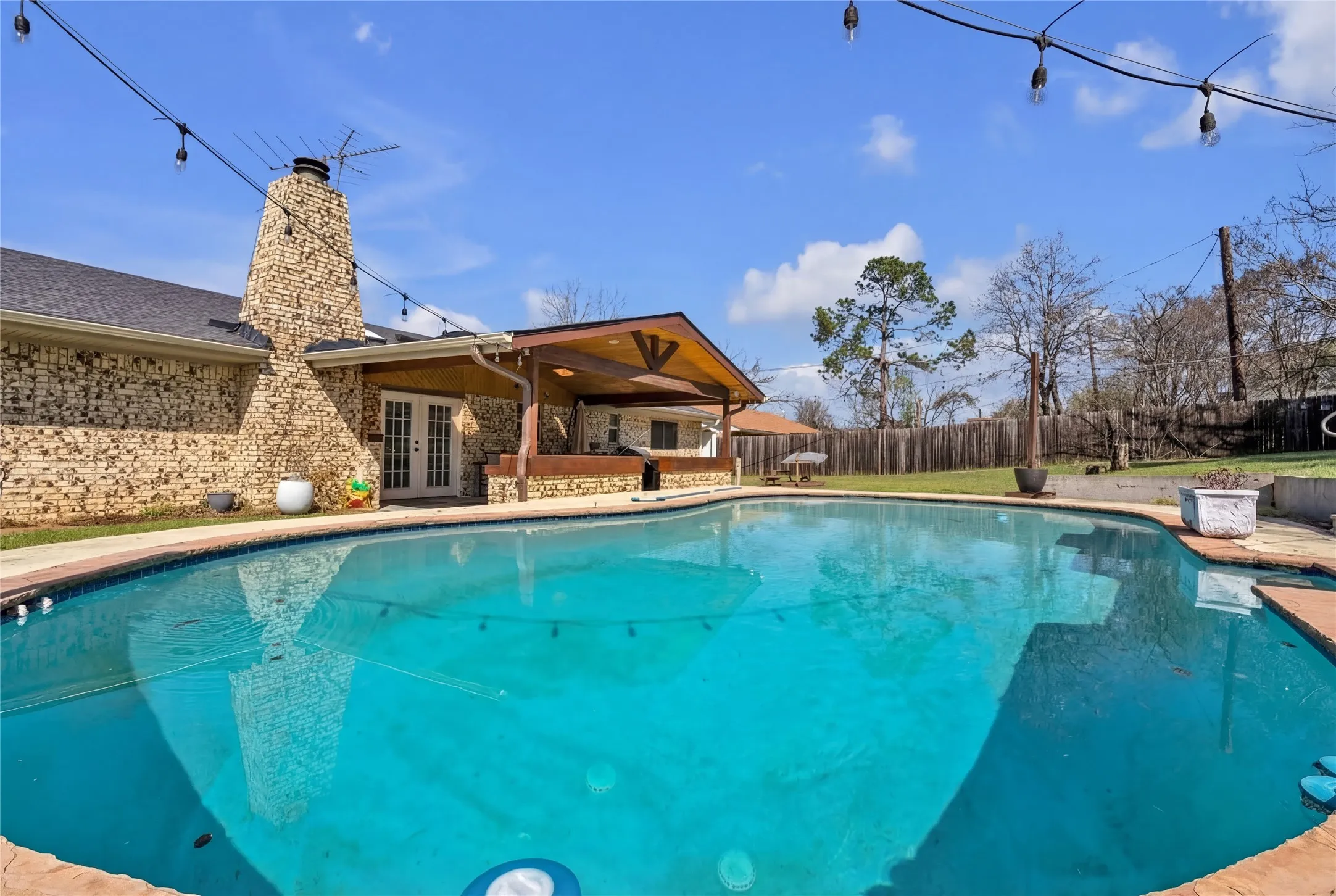 Outdoor swimming pool with brick coping and concrete deck surround