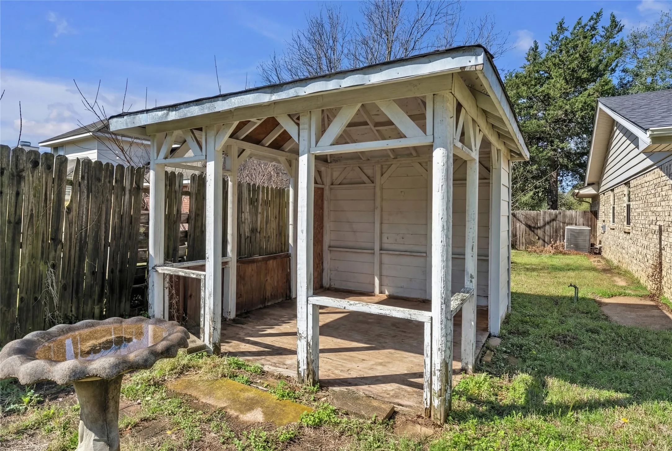 Outdoor gazebo structure with a pitched roof and a concrete floor
