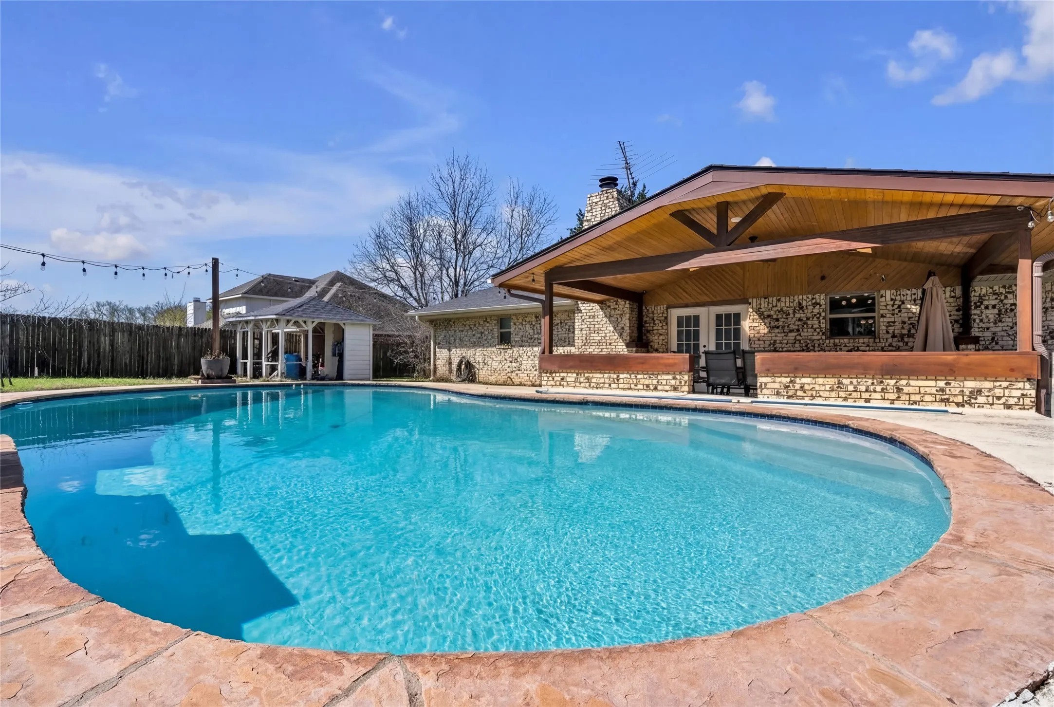 Oval-shaped swimming pool with a natural stone coping