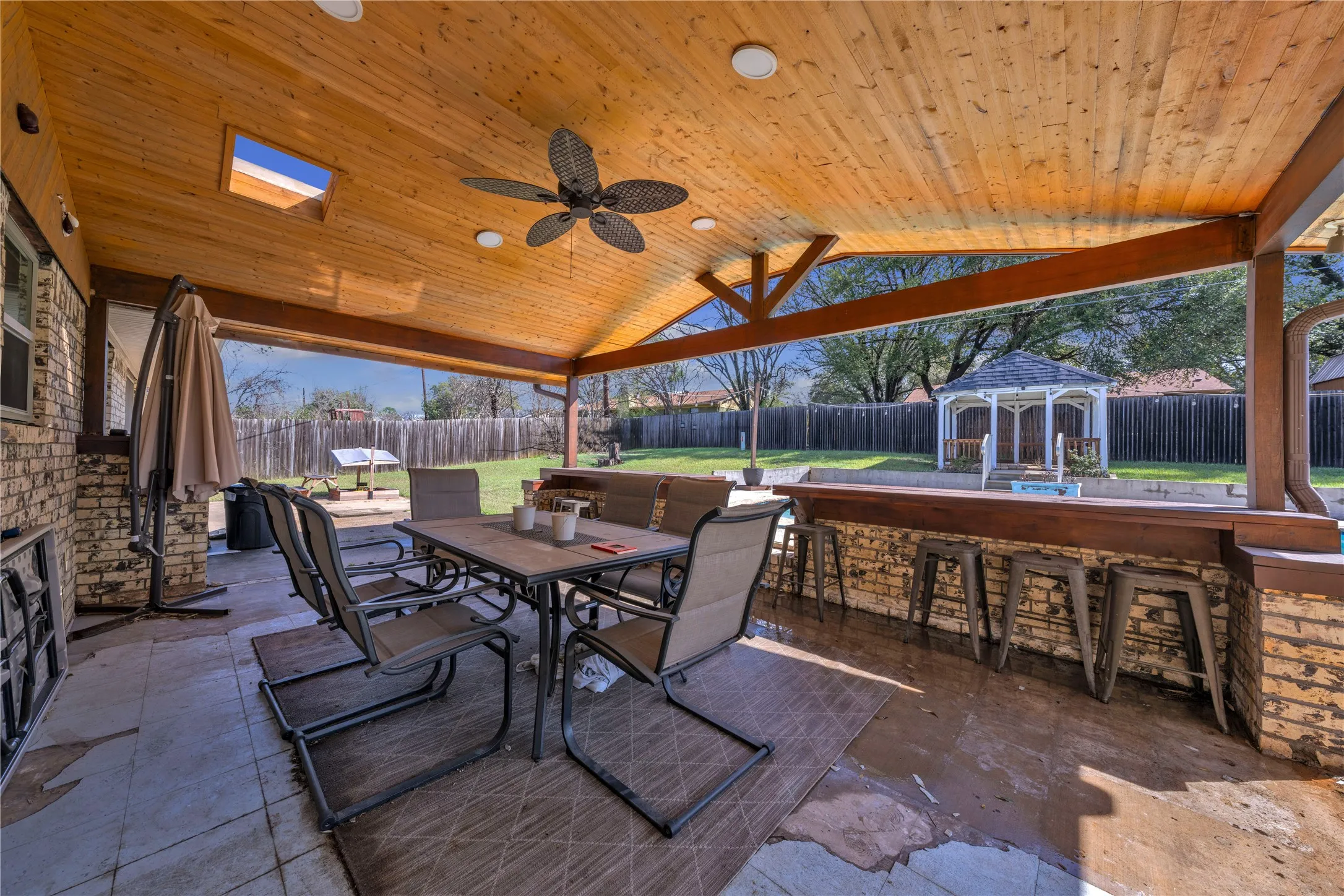 Covered patio featuring a high vaulted wood-paneled ceiling with a skylight and recessed lighting