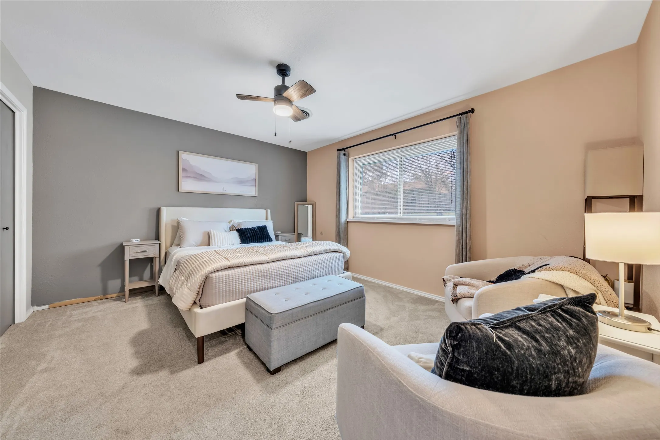 Carpeted bedroom with a window, ceiling fan, and contrasting wall colors