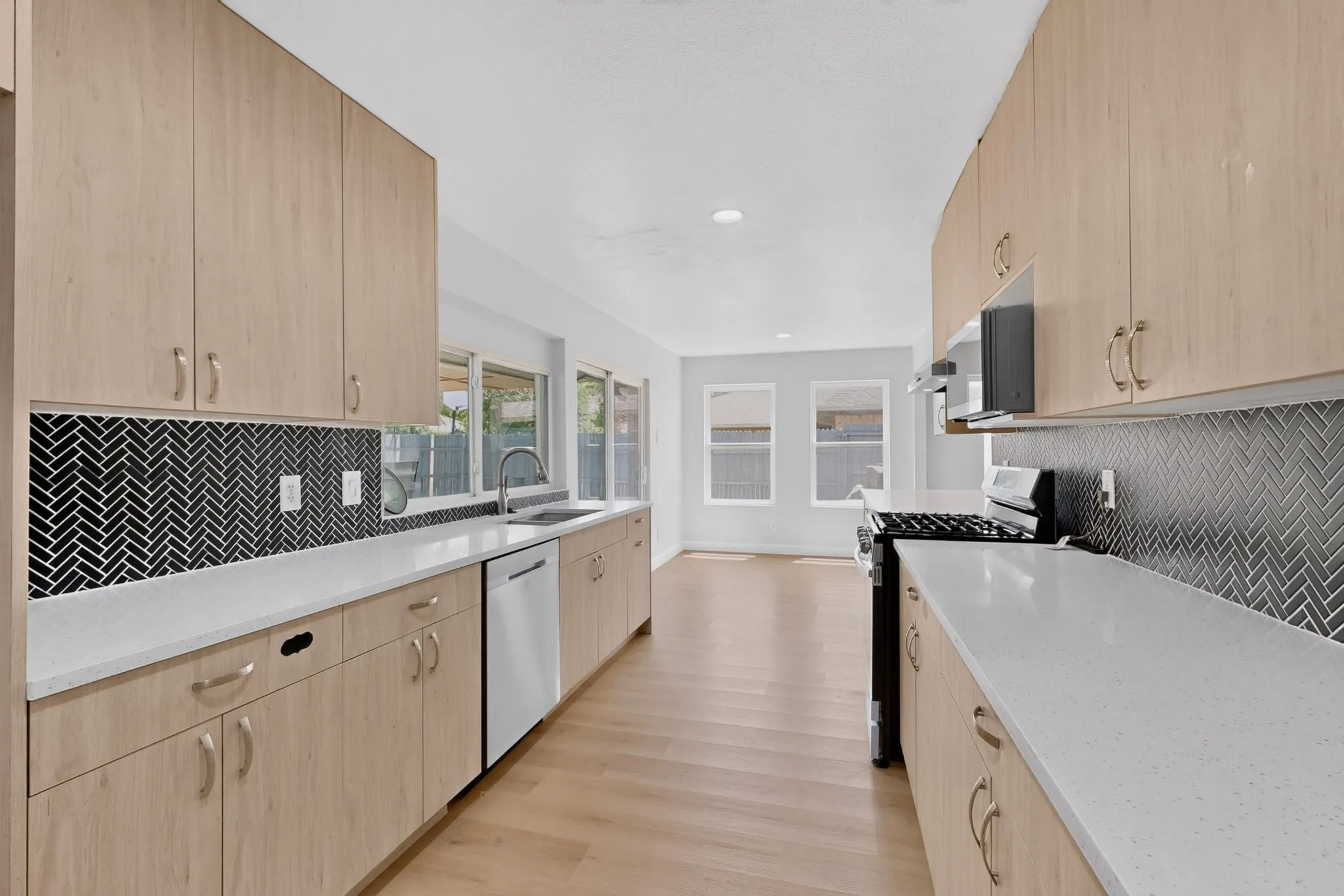 Modern kitchen featuring light wood-finish cabinetry and white countertops