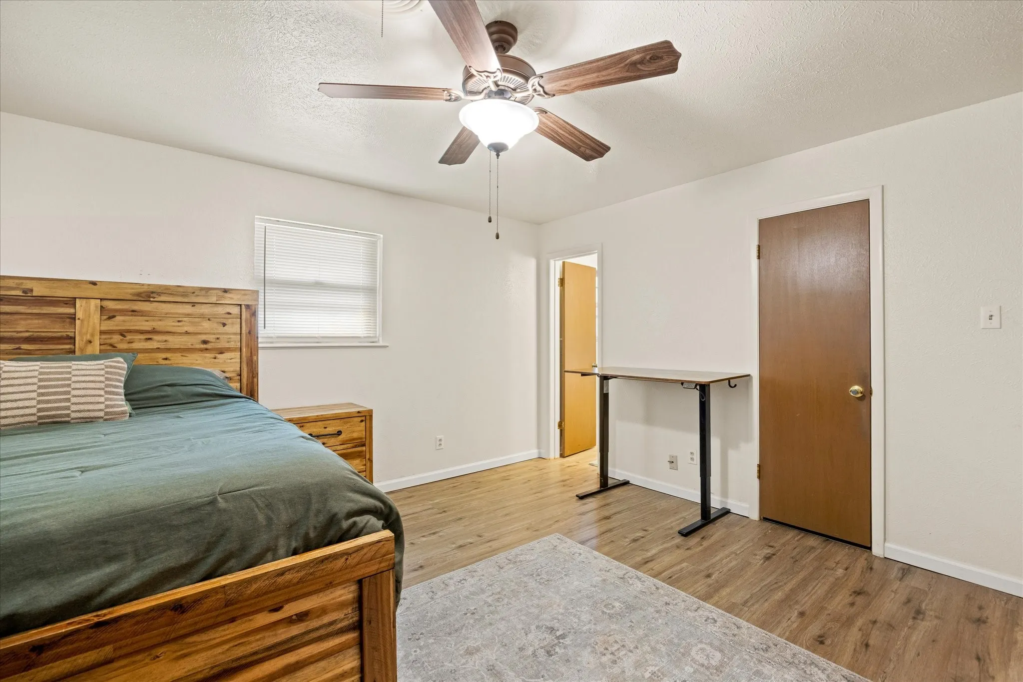 Primary Room featuring wood-finish flooring, a ceiling fan with integrated lighting, and white walls