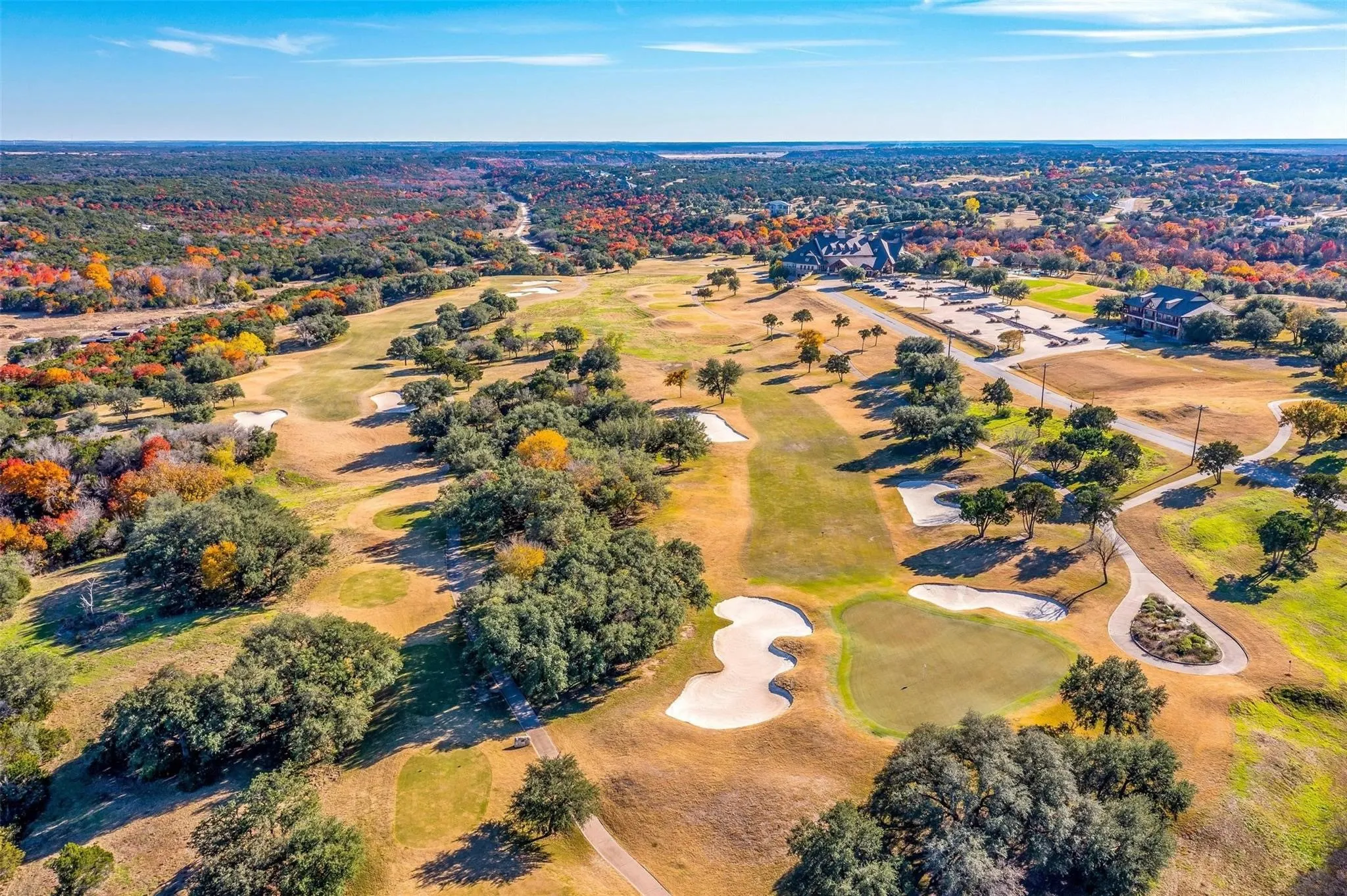 Championship 18 hole golf course with rolling hills, trees, waterfall, and cliffside.