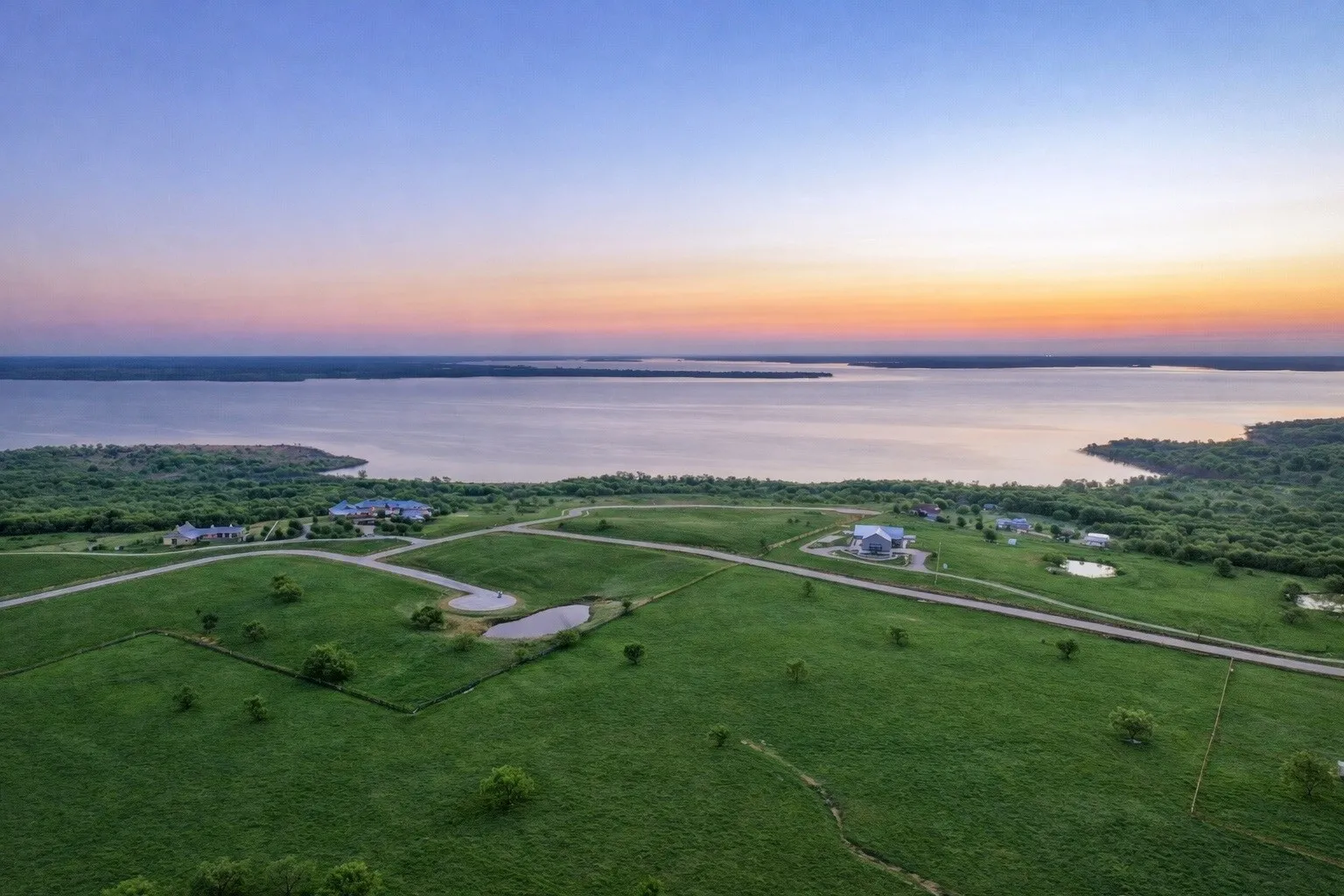 Expansive acreage featuring a broad lake shoreline, mature tree lines, and multiple small ponds