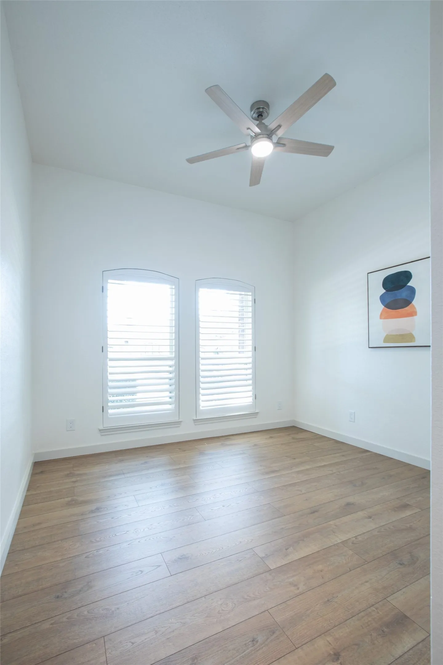Freshly updated secondary bedroom featuring new paint, new windows and trim, a new ceiling fan, and updated door hardware throughout.