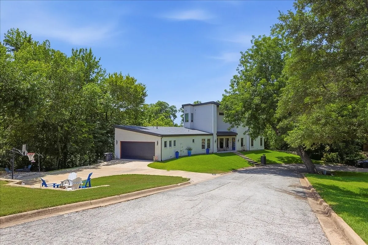 Modern white exterior featuring a sloped roofline, attached garage, and multiple windows