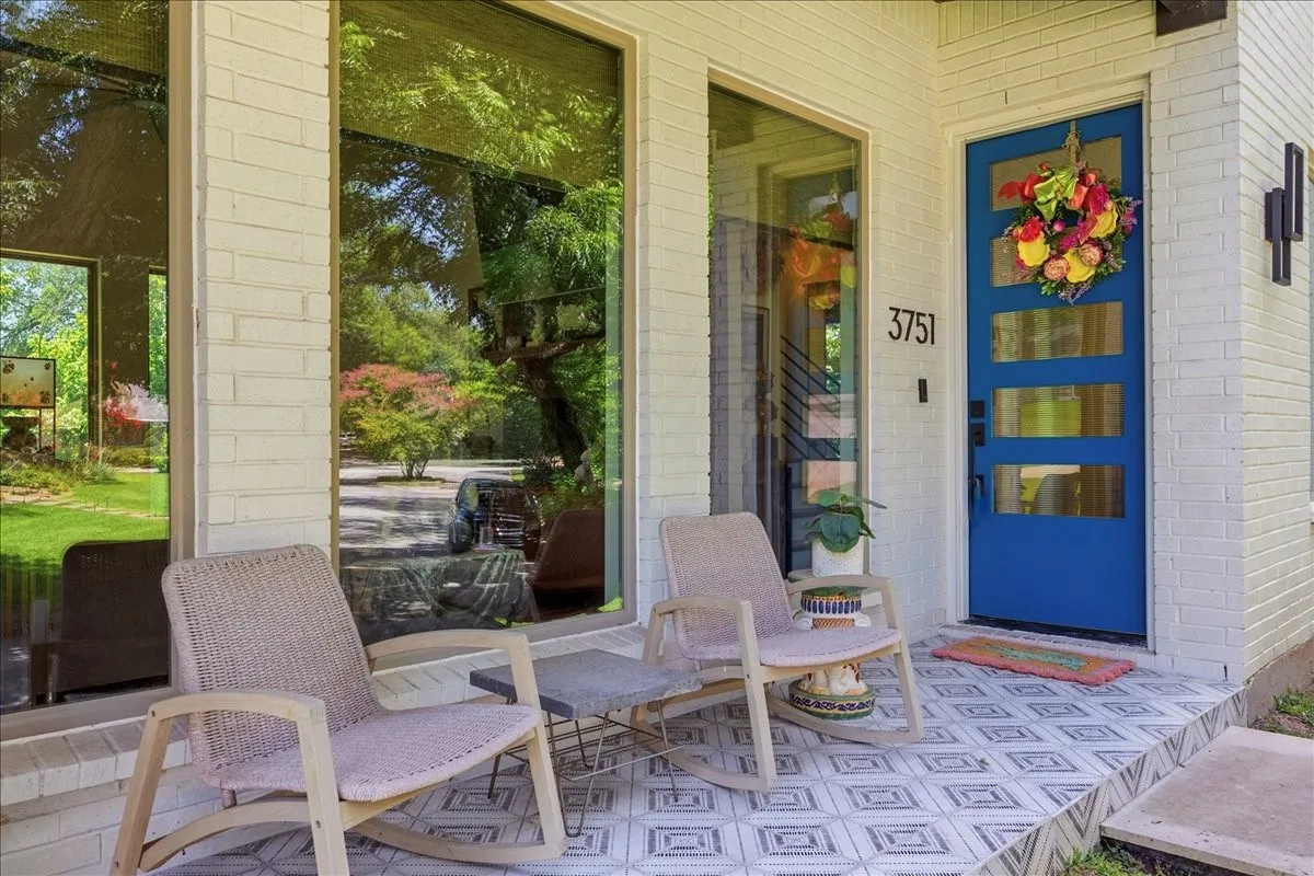White brick exterior with a vibrant blue entry door featuring four horizontal glass panels