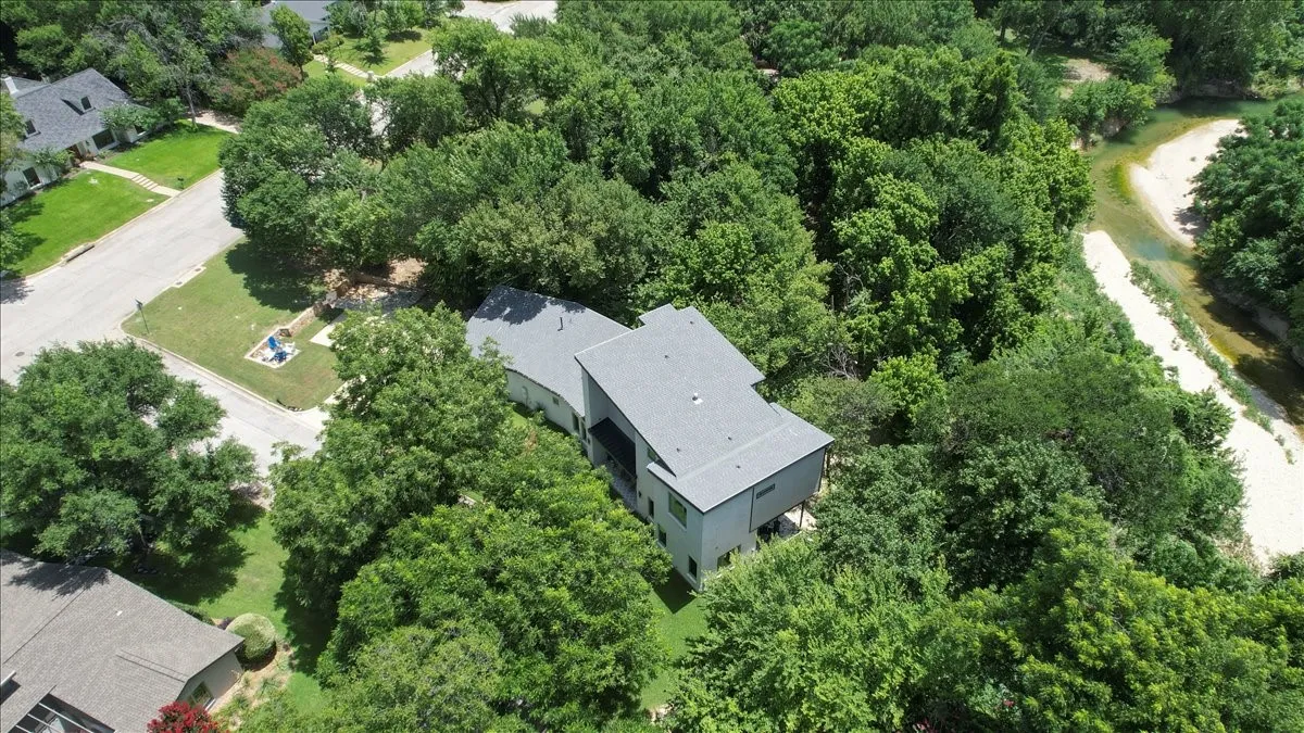 Modern roofline structure surrounded by mature trees
