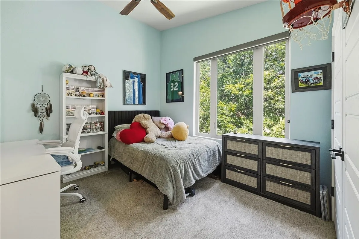 Room featuring light blue walls, light-colored carpeting, and a ceiling fan