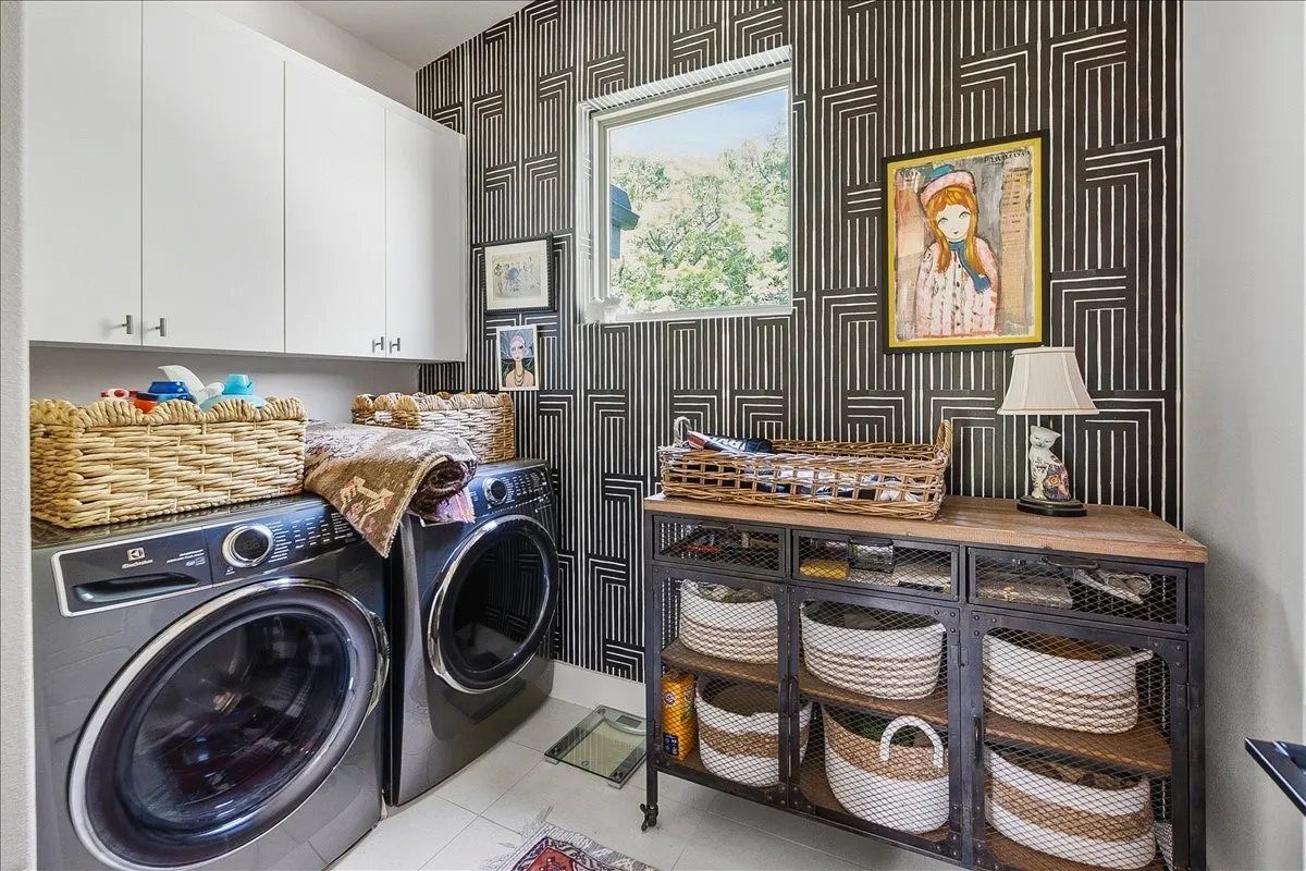 Laundry area featuring a black and white geometric patterned accent wall