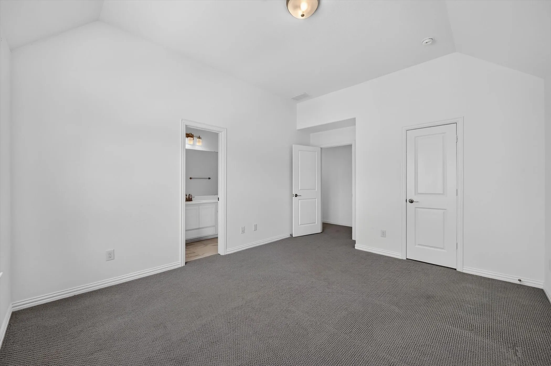 Vaulted ceilings over gray carpeting