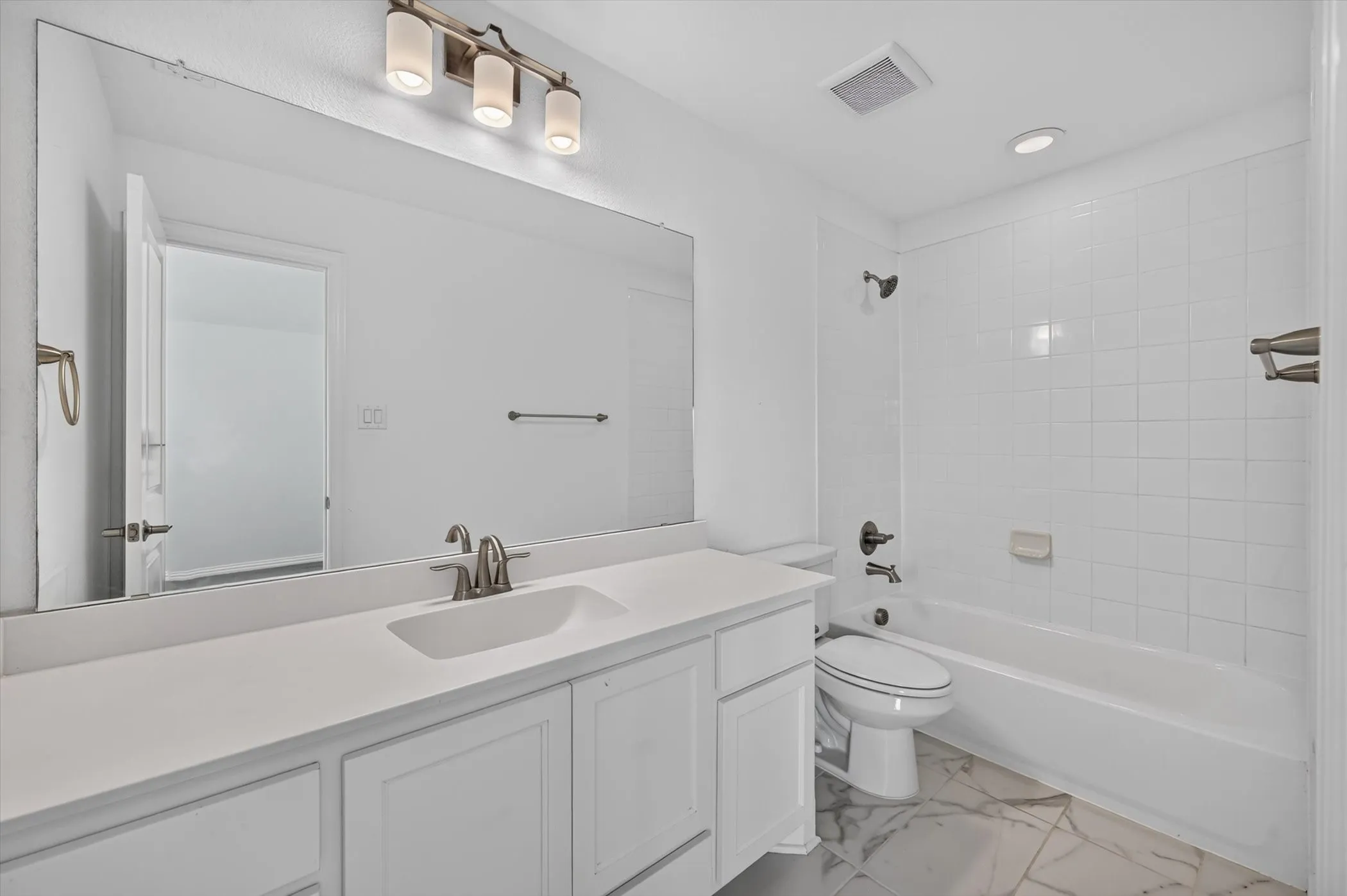 Bathroom featuring a wide vanity with an integrated sink, white cabinetry, and brushed nickel fixtures