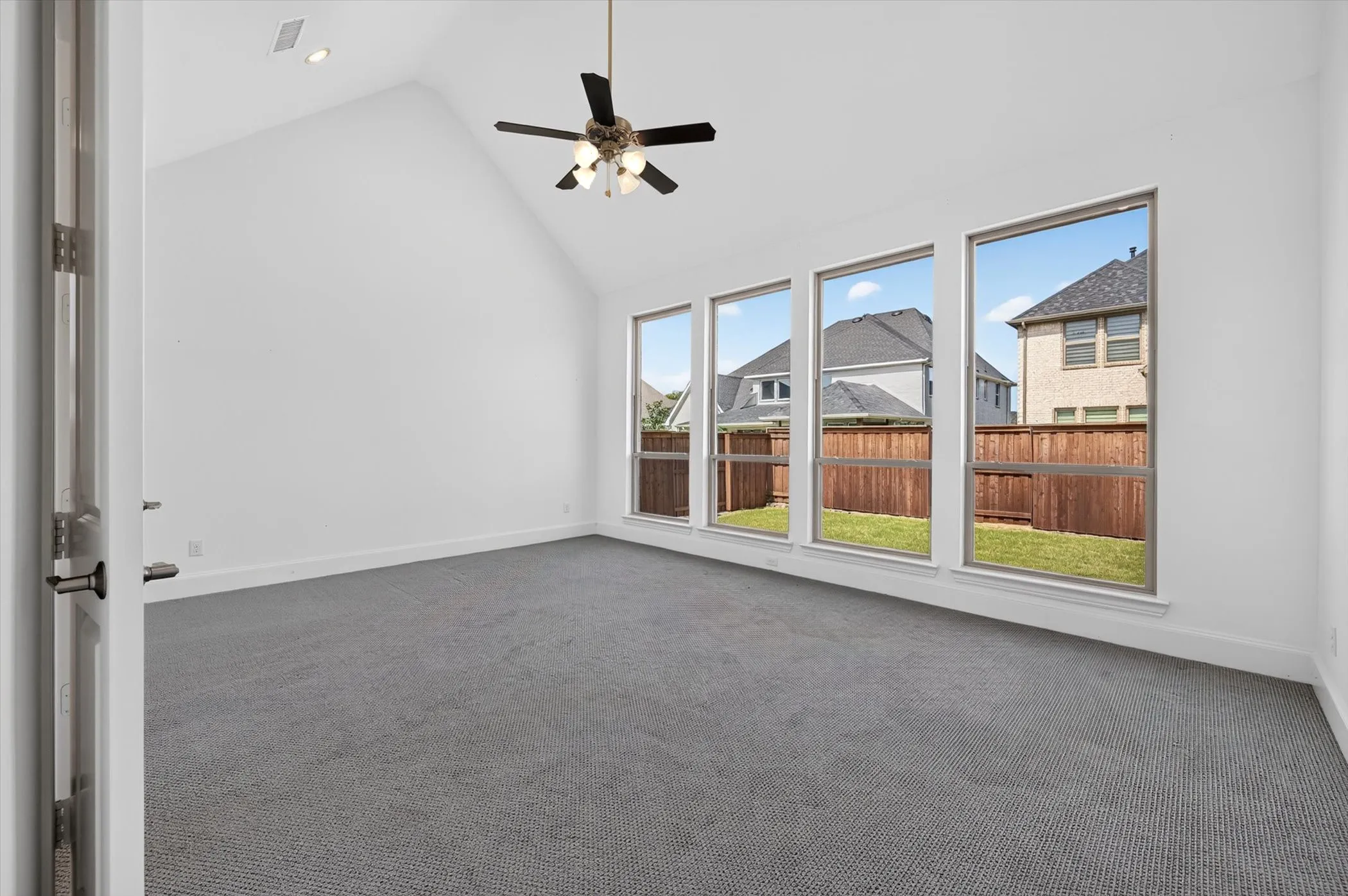Vaulted ceiling room featuring four tall picture windows