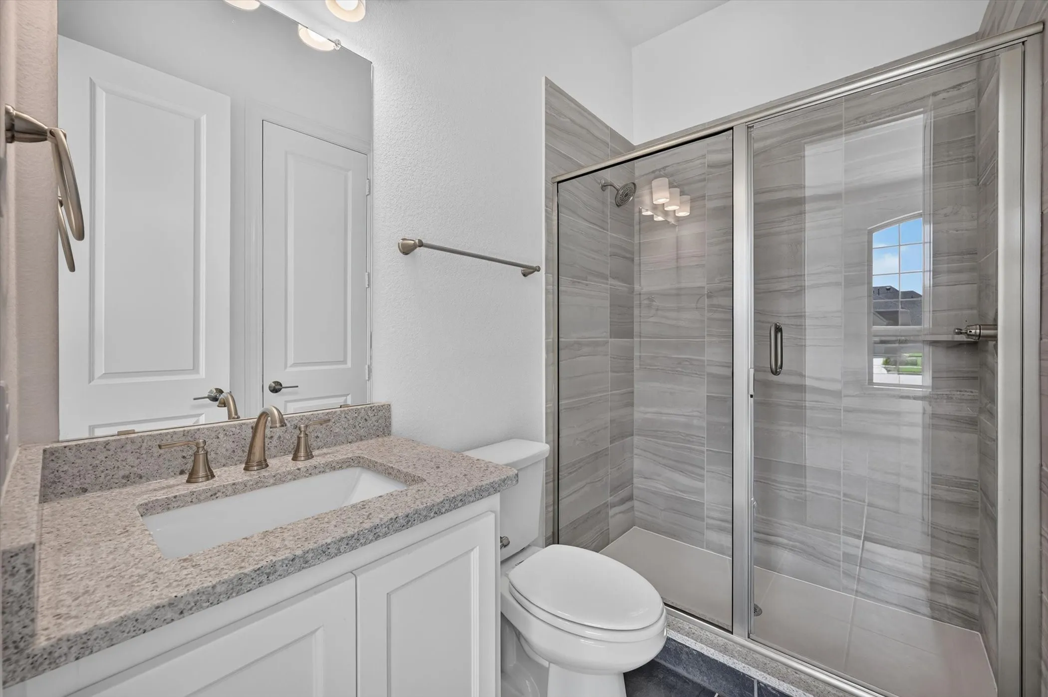 Walk-in shower with glass enclosure and tiled surround