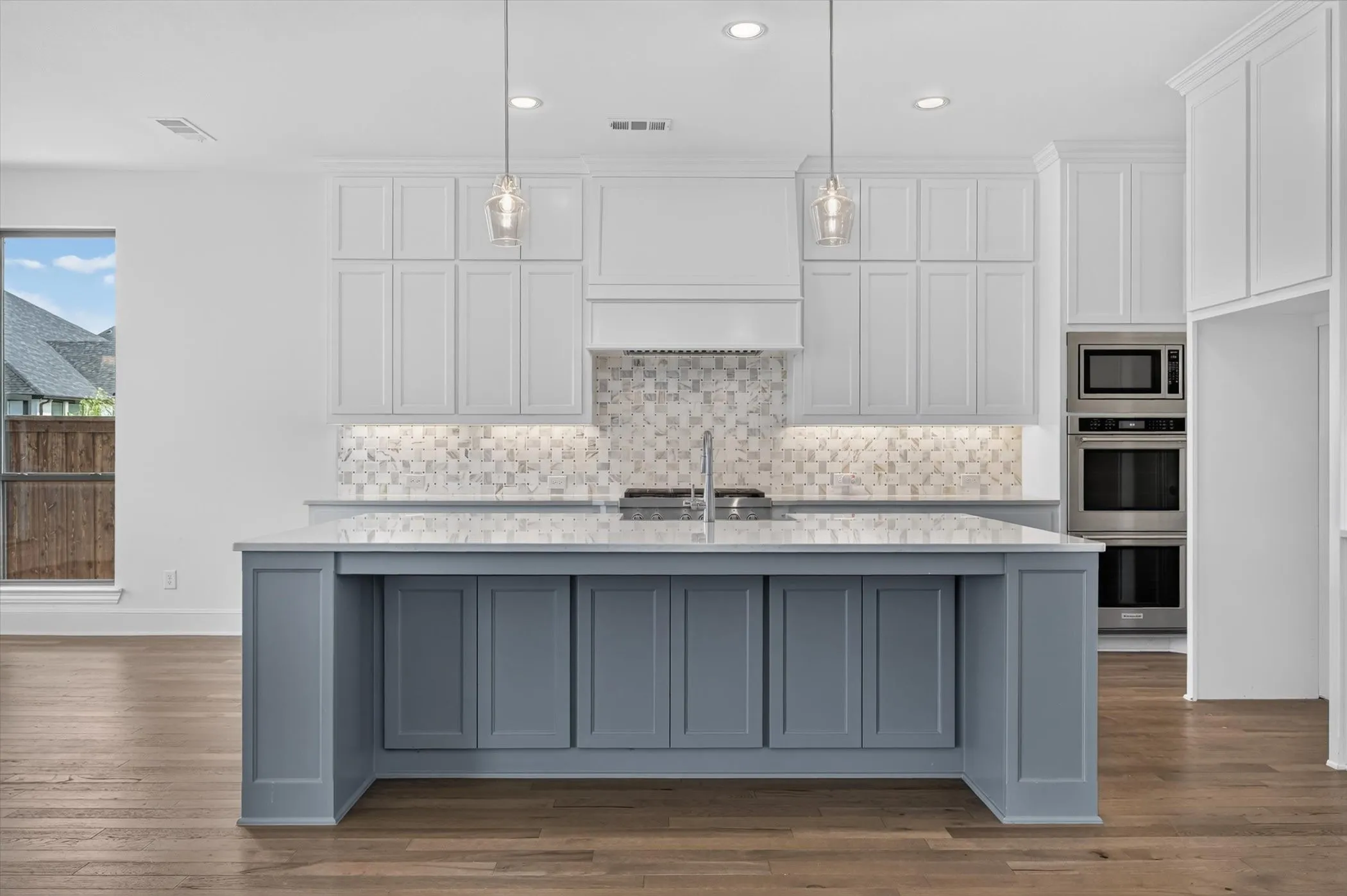 Central kitchen island with blue-painted cabinetry and a light-toned countertop