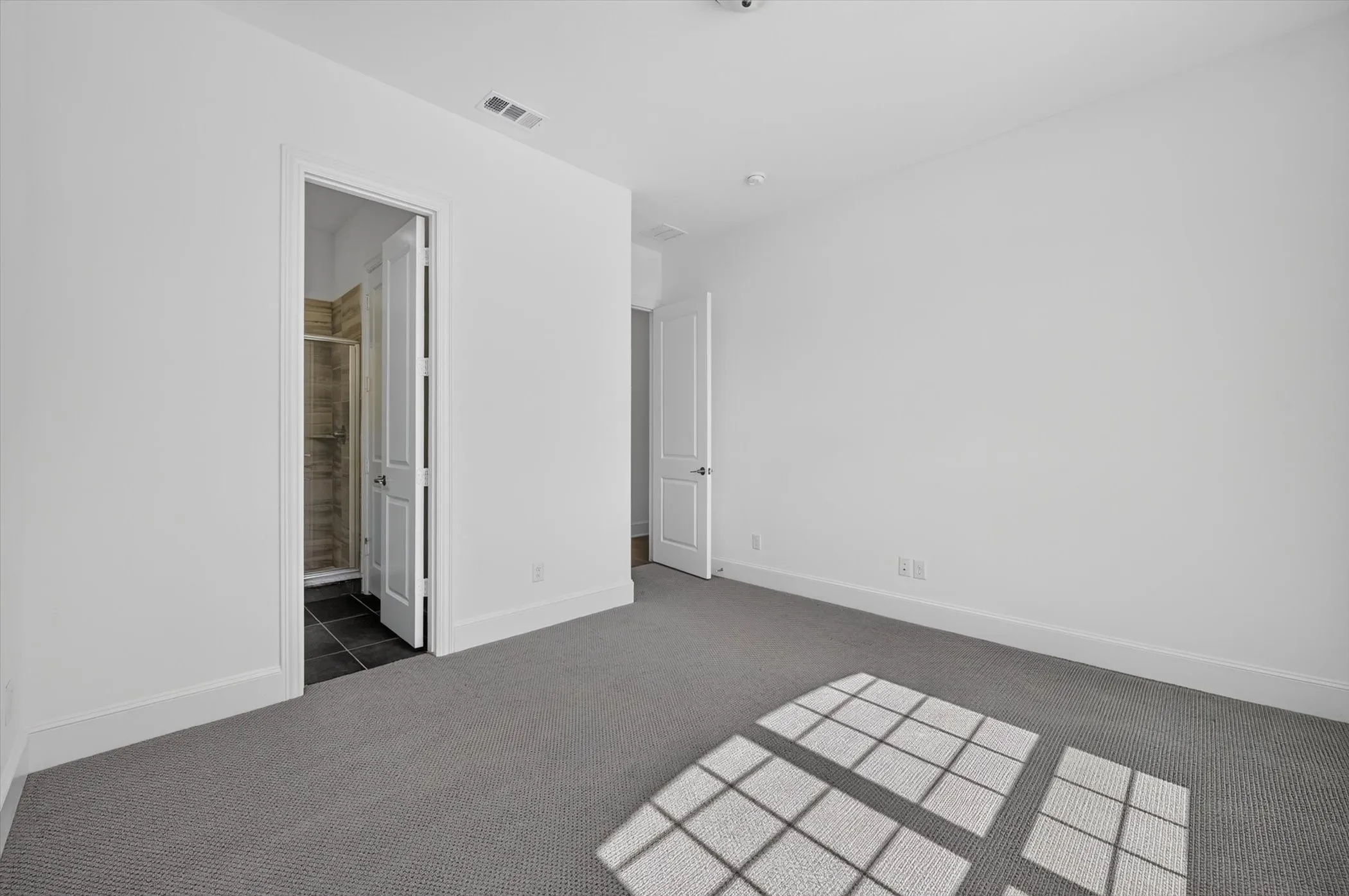 Carpeted interior room featuring white walls and baseboards
