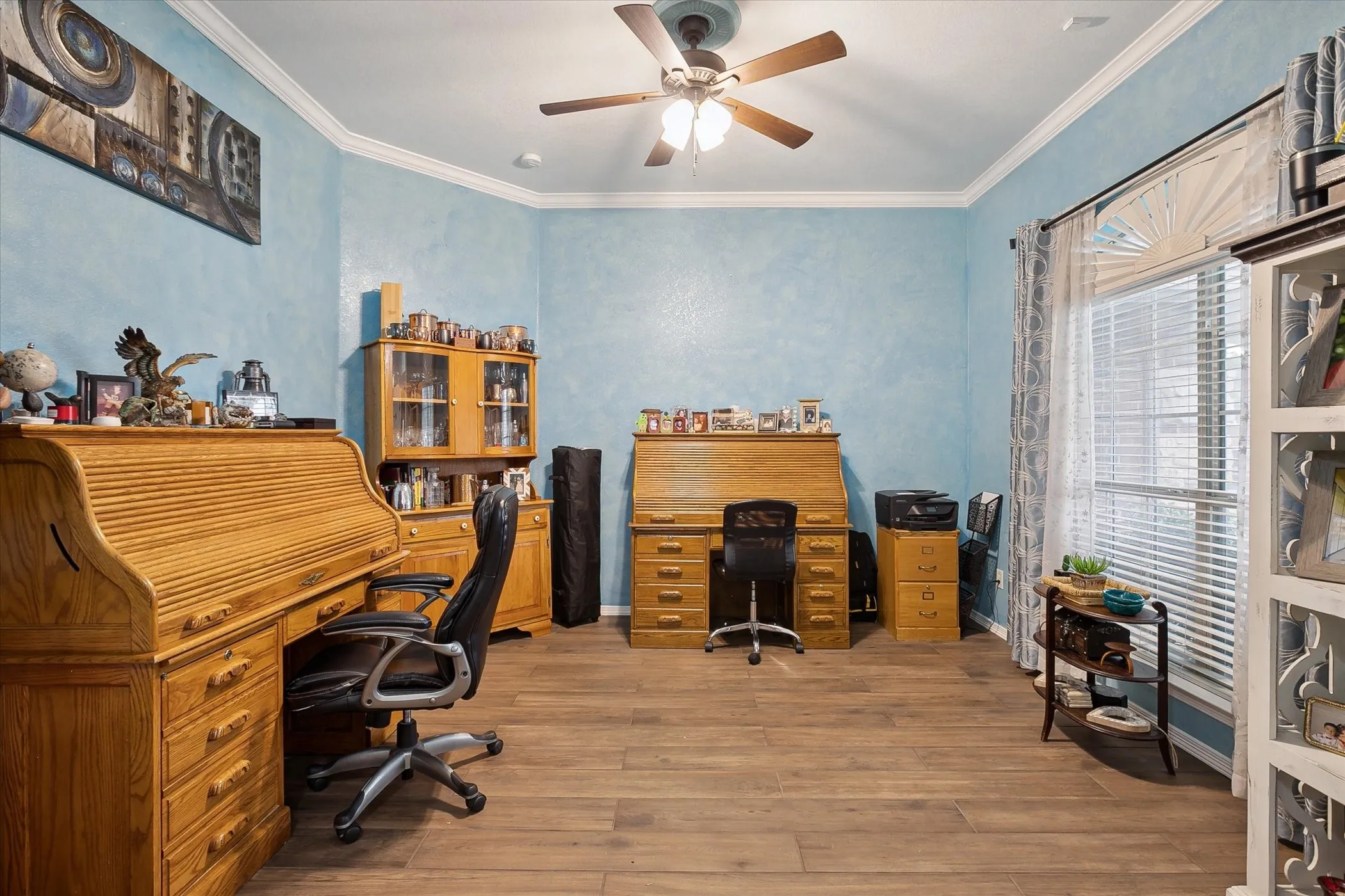 Spacious office with crown molding and ceiling fan.