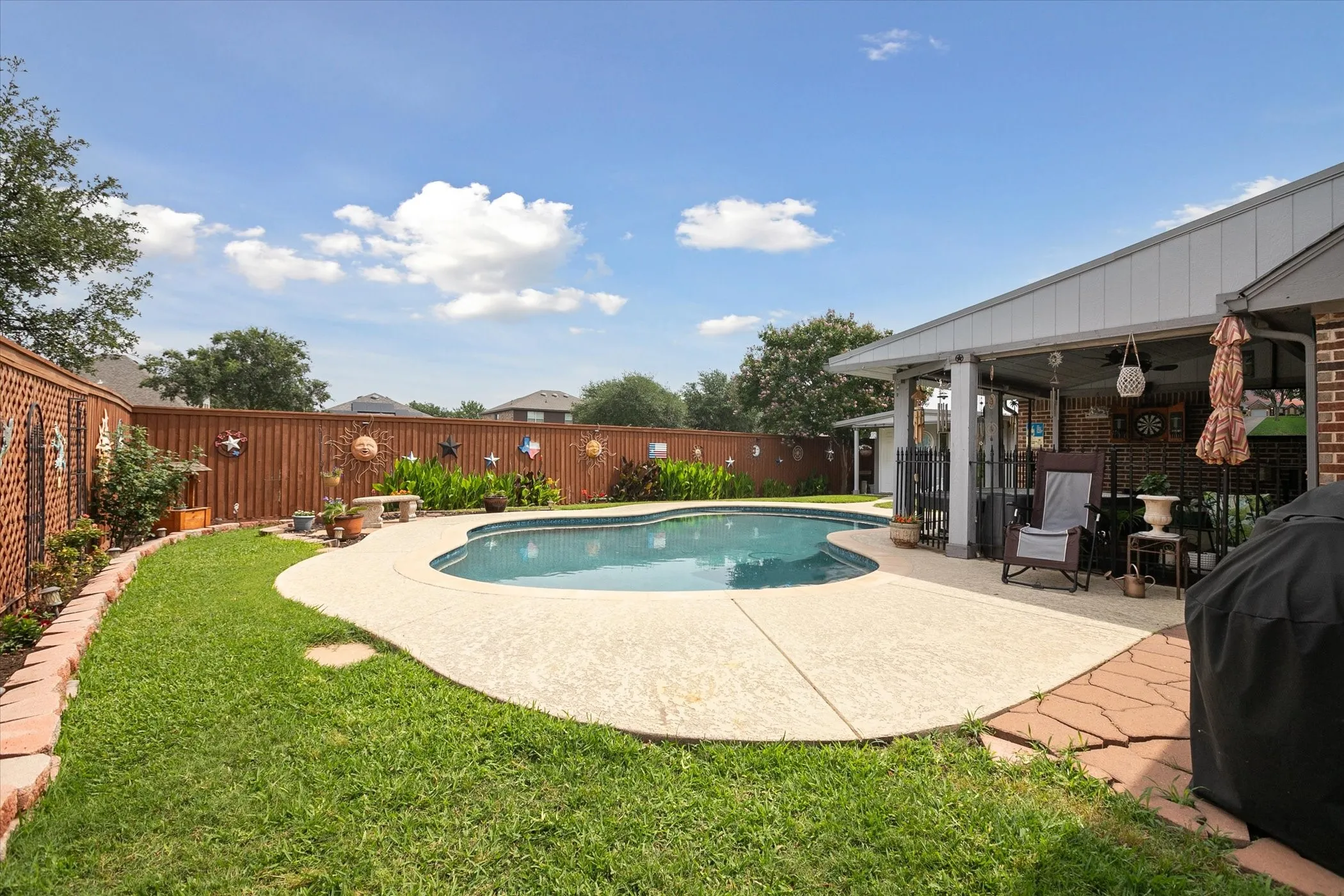 Curved inground pool with surrounding concrete decking