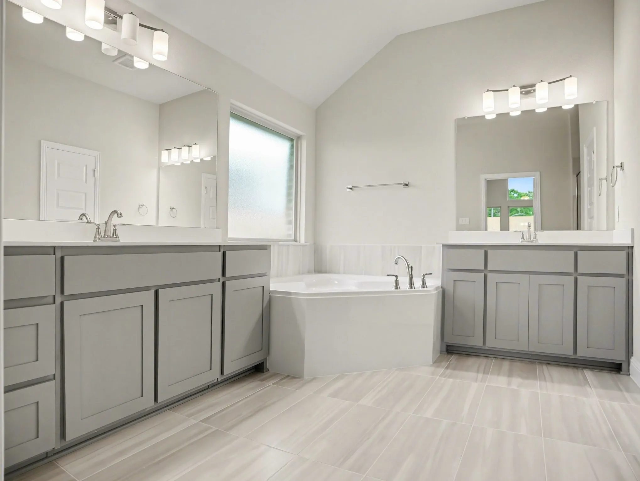 Spacious bathroom featuring a built-in corner soaking tub, dual vanities with light gray cabinetry and white countertops, and wood-finish tile flooring