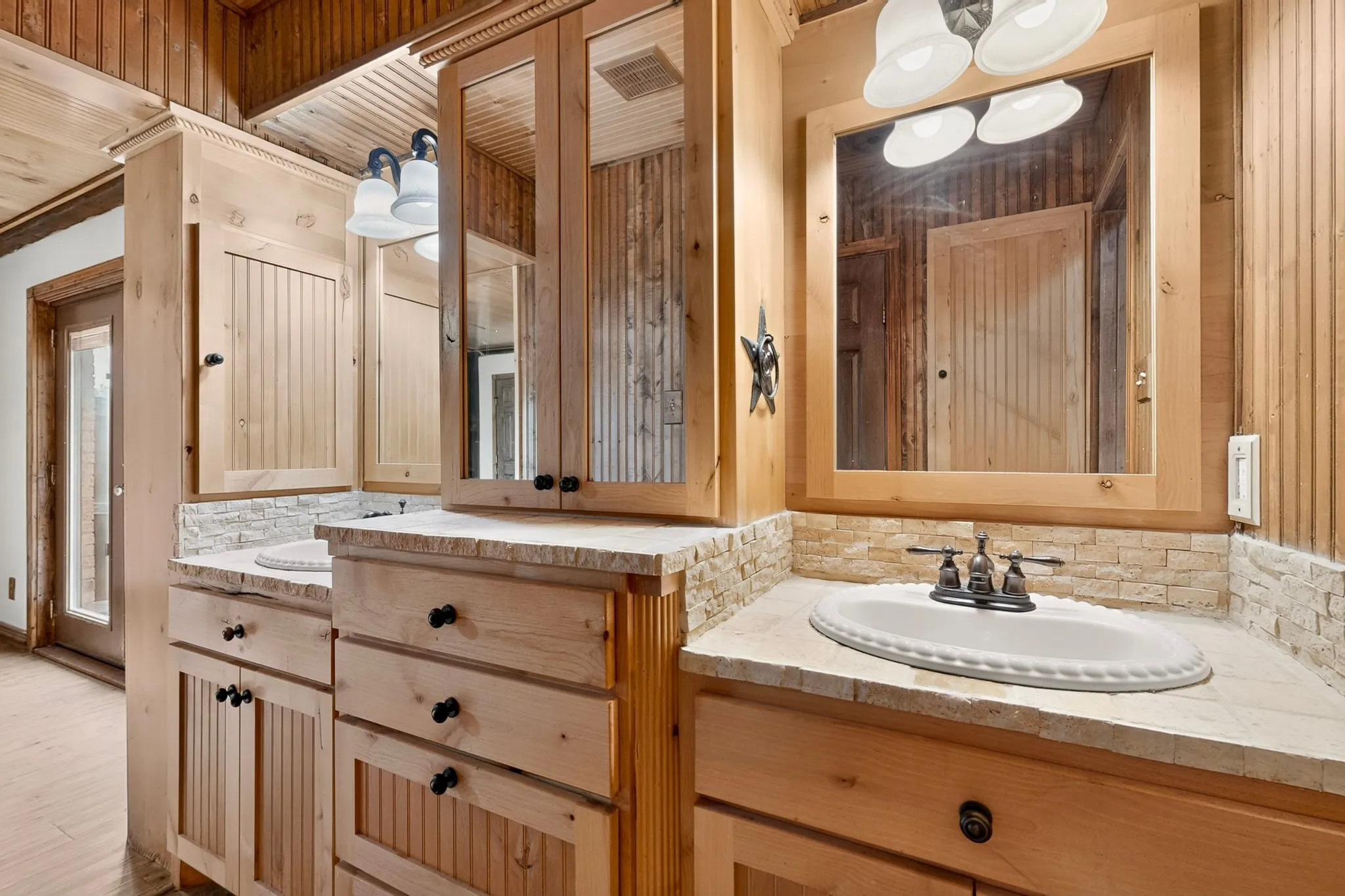 Dual vanity with light wood cabinetry and built-in medicine​​‌​​​​‌​​‌‌​‌‌​​​‌‌​‌​‌​‌​​​‌​​ cabinets