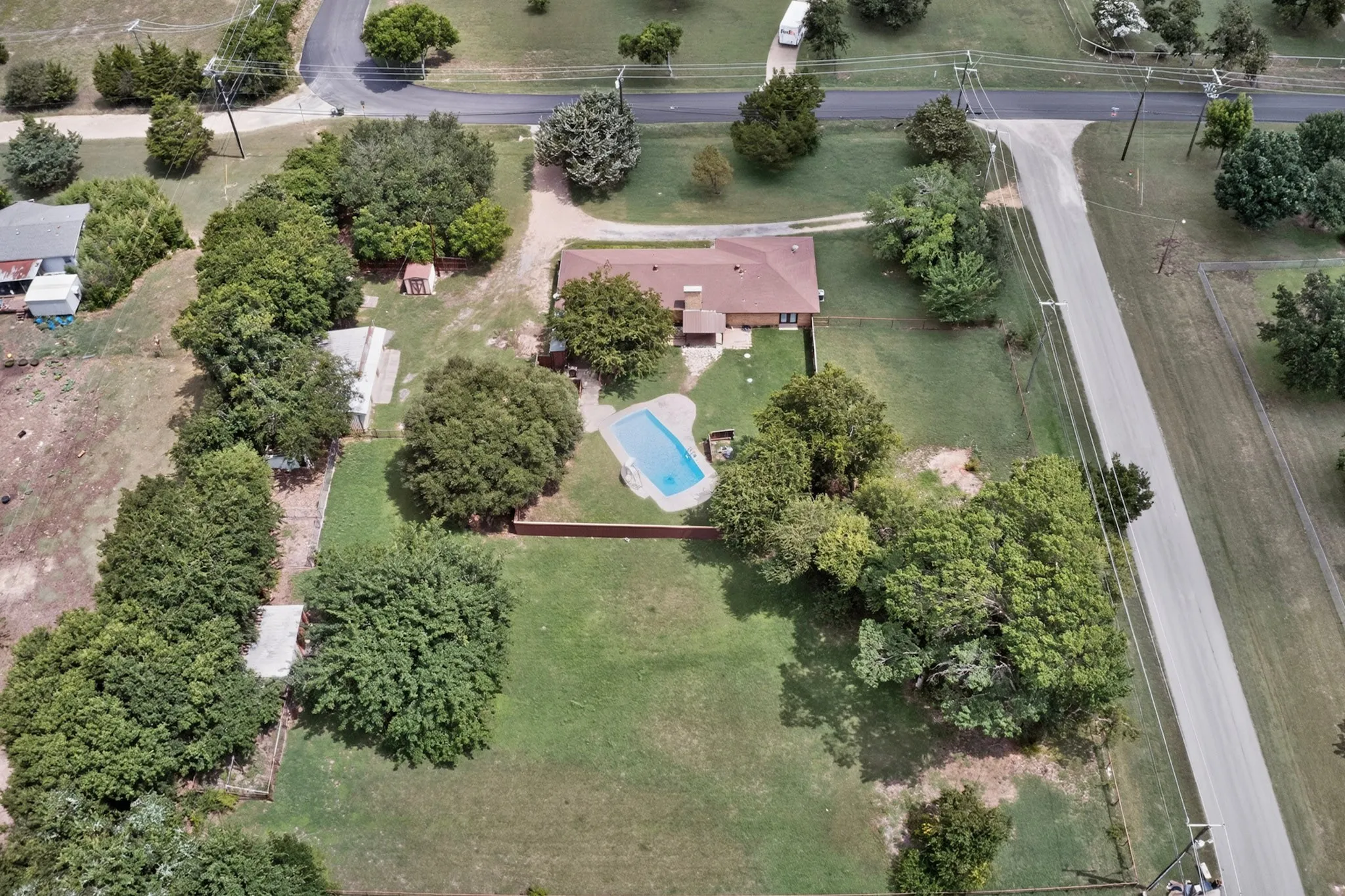 Aerial depiction of a property featuring a single-story residence with a red-brown roof