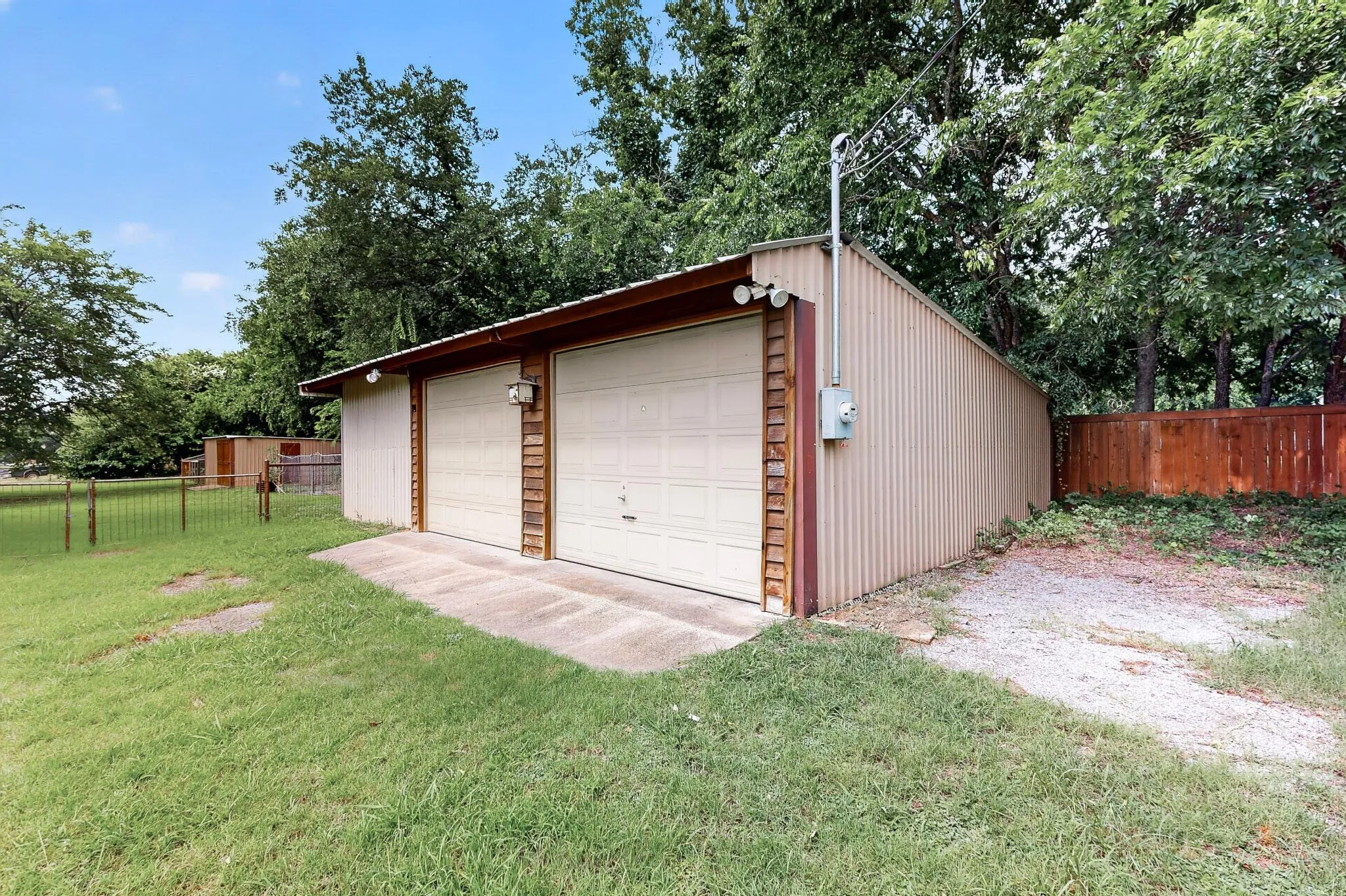 Detached two-car garage with corrugated metal siding and two overhead doors