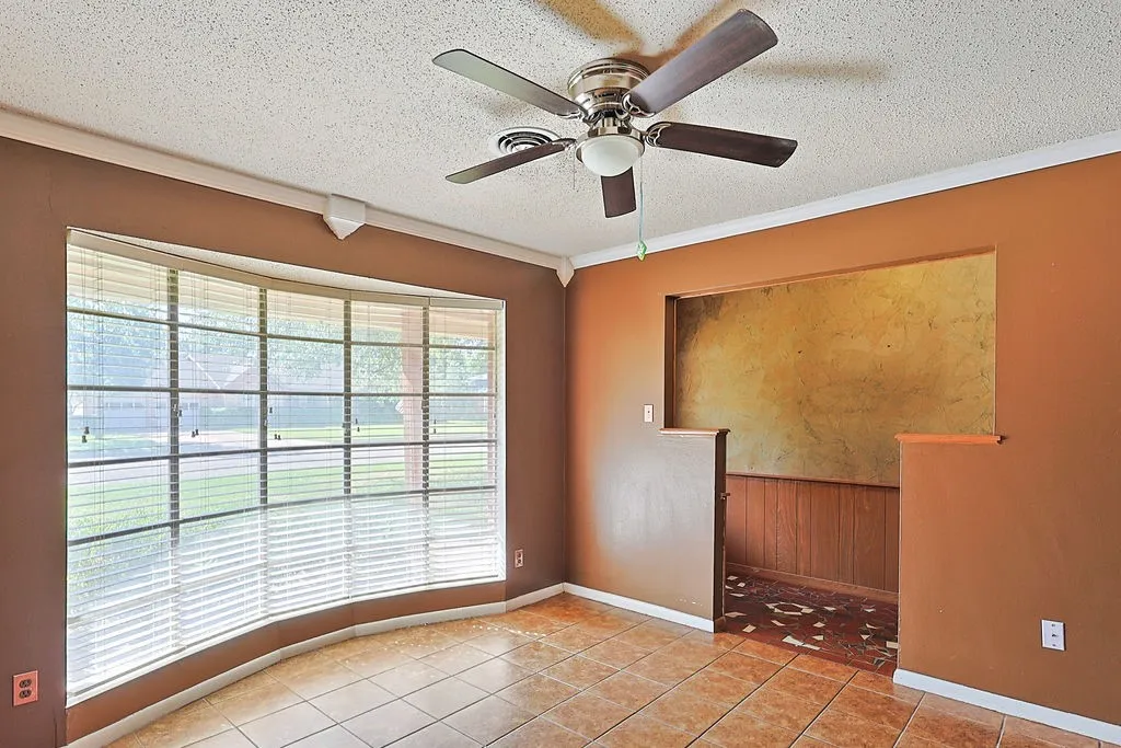 Curved bay window with horizontal blinds and an overhead ceiling fan