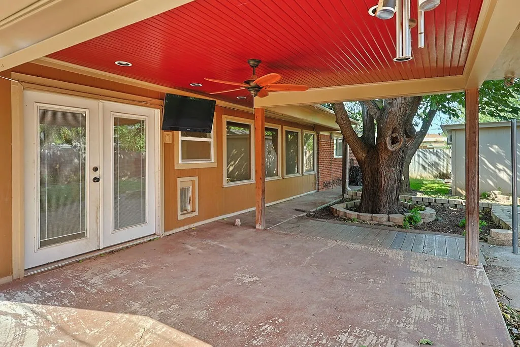 Covered patio featuring a red paneled ceiling with a ceiling fan, recessed lighting, and an attached light fixture