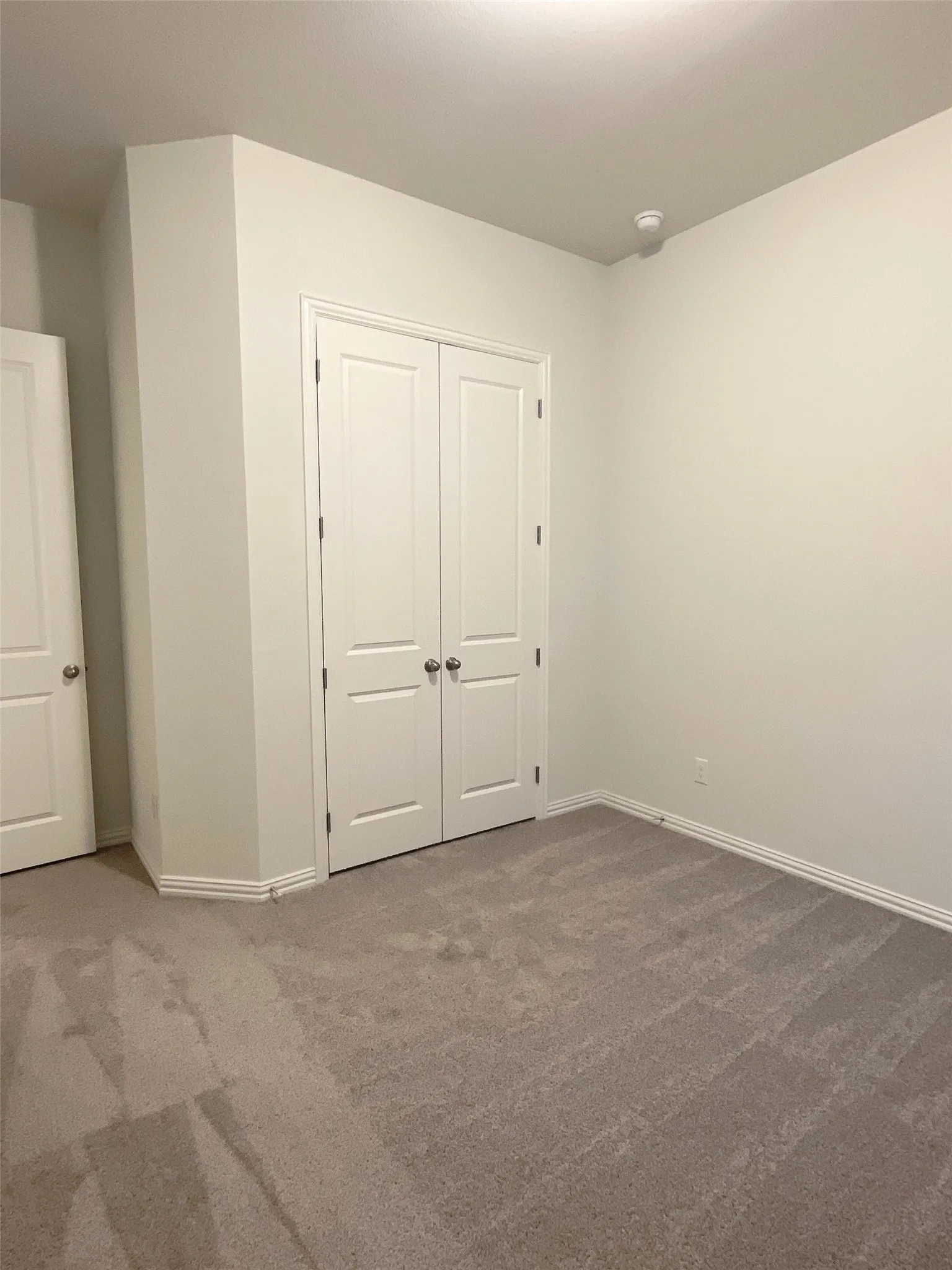 Unfurnished bedroom with a closet, carpet flooring, and baseboards