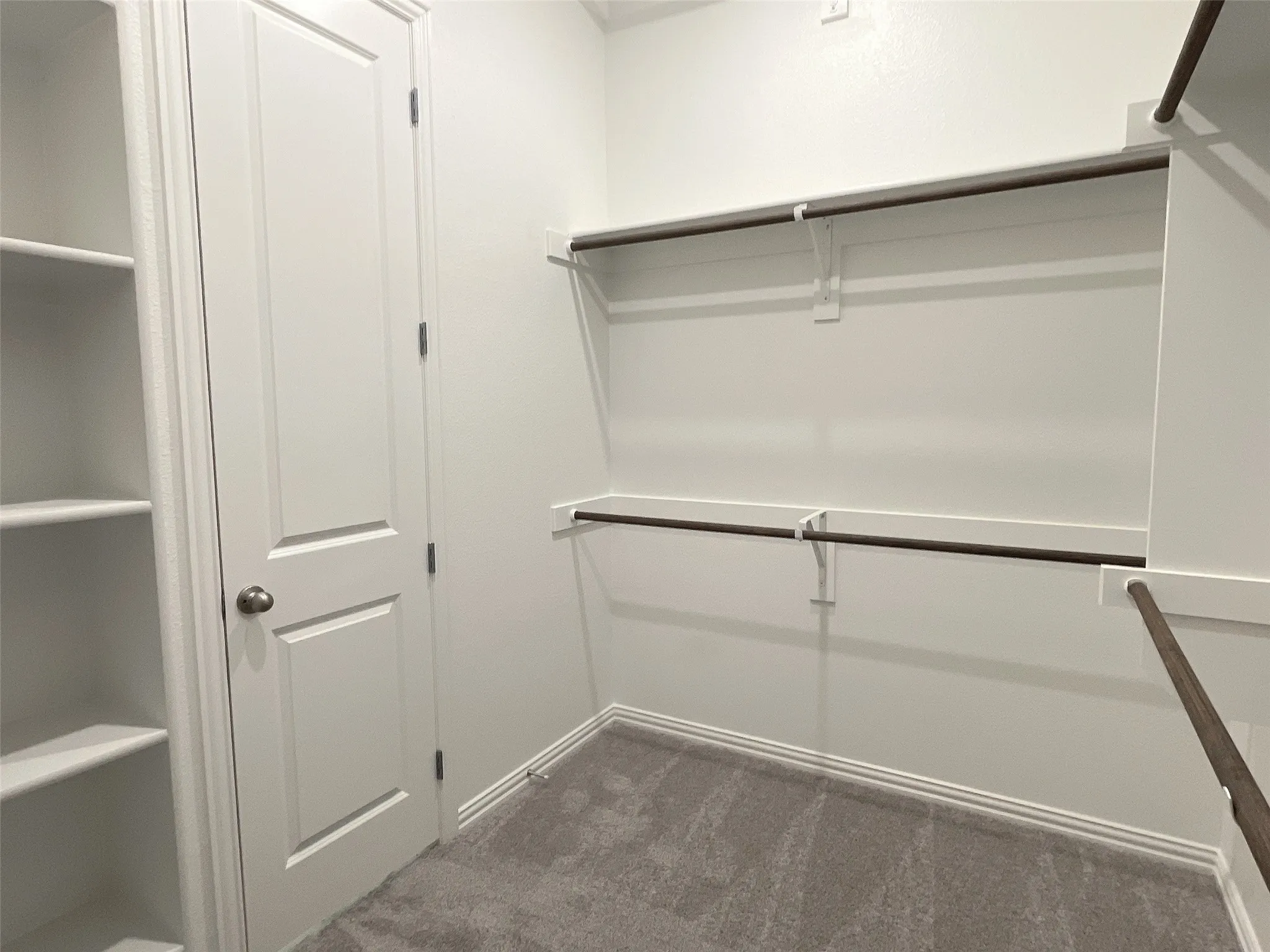 Spacious closet with dark carpet