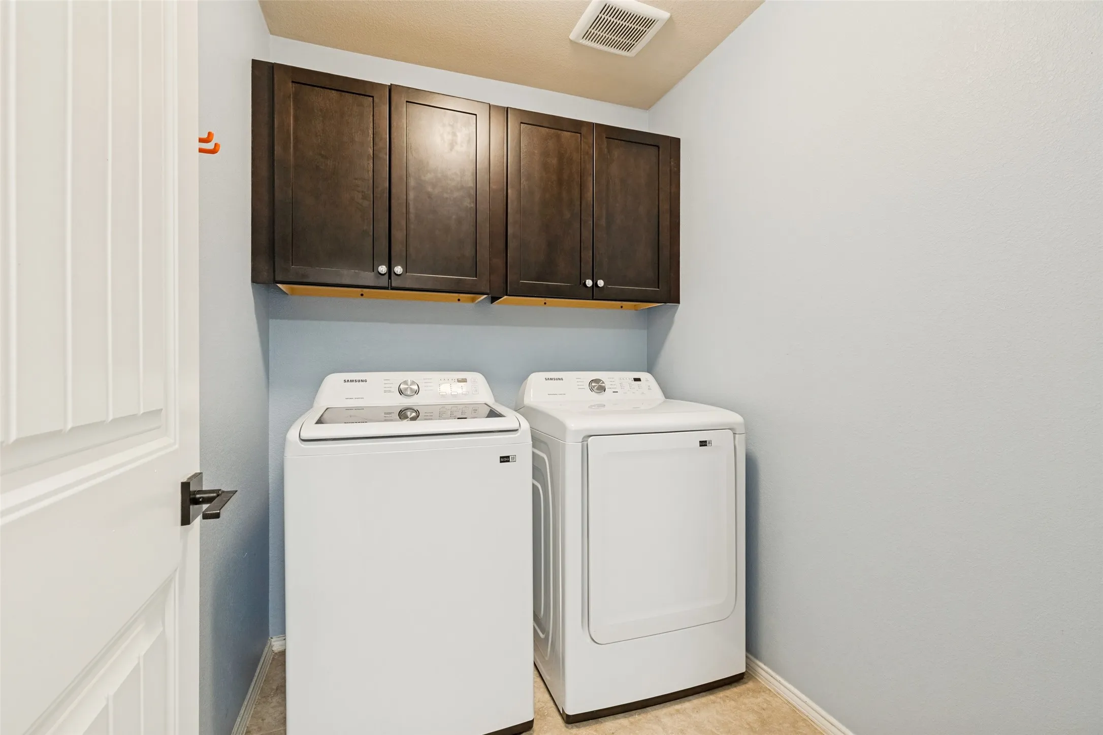 A separate laundry room with high end cabinetry