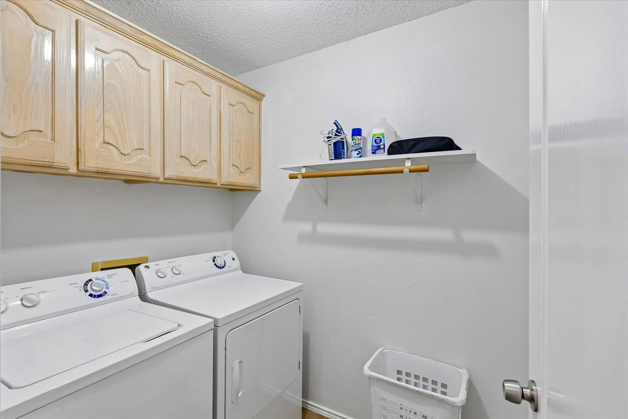 Dedicated utility room with built in cabinet and space for hanging your clothes.