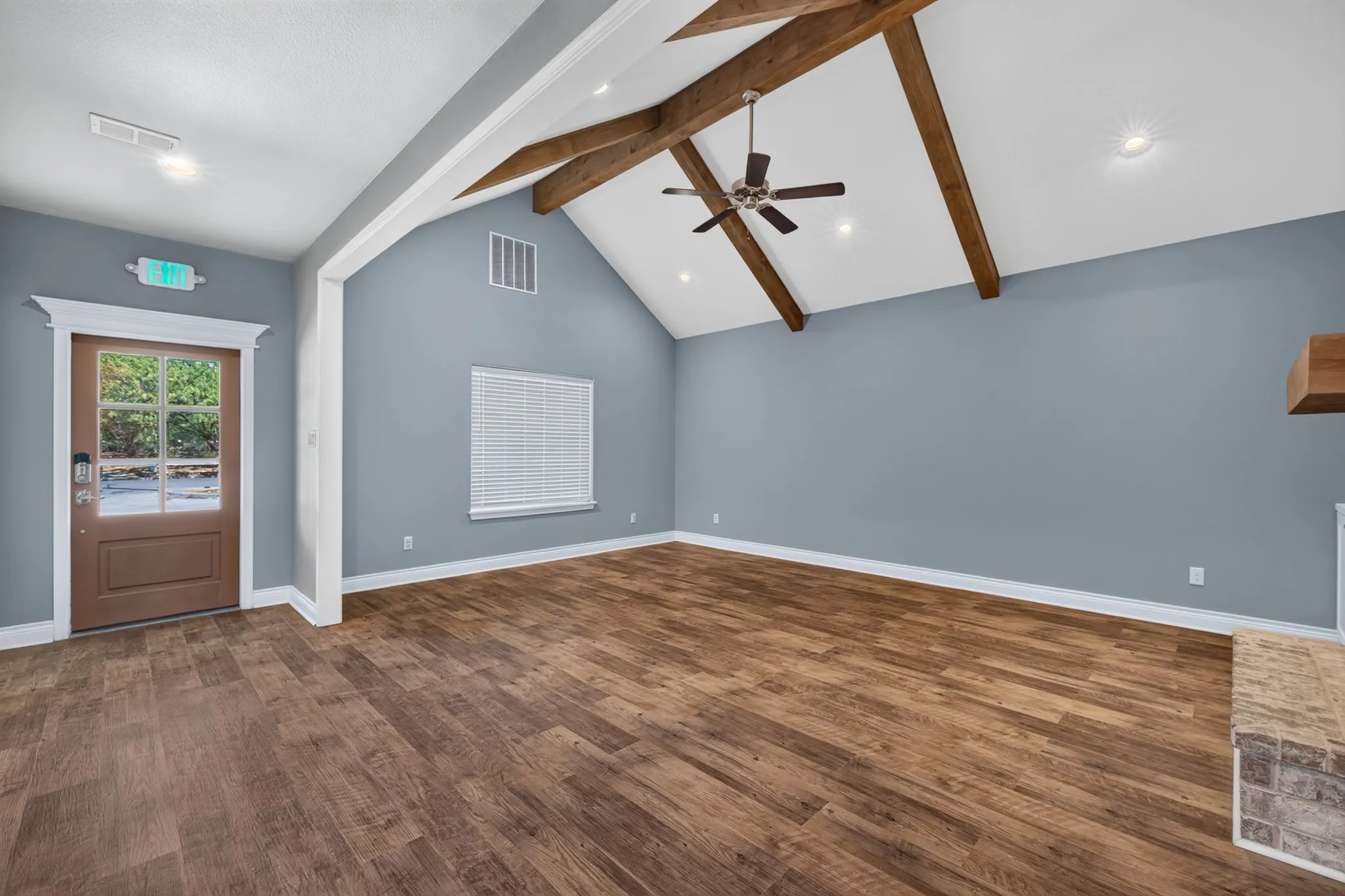 Vaulted ceiling with exposed wood beams, wood-finish flooring, ceiling fan, recessed lighting, and a window with blinds